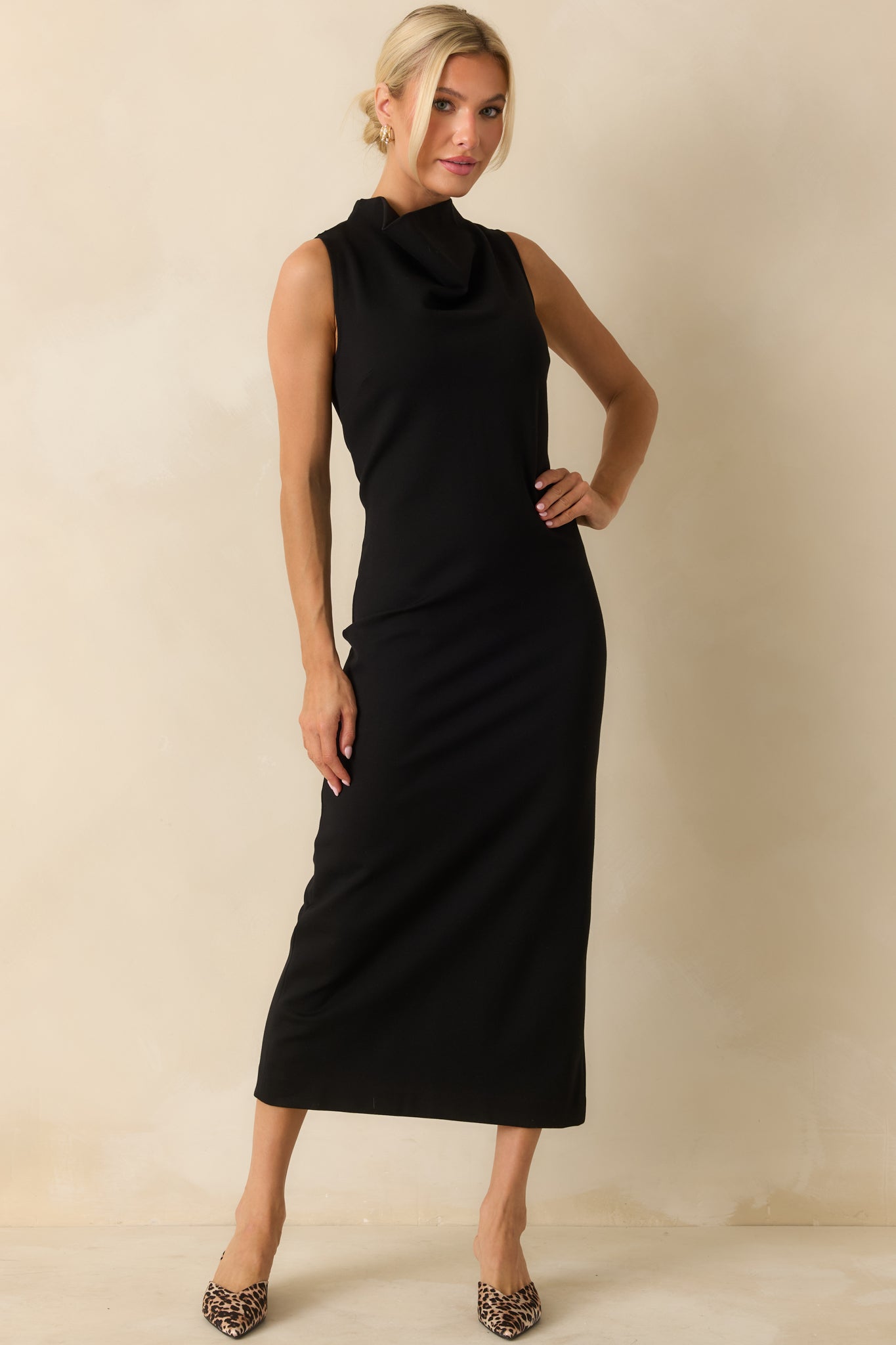 Figure-enhancing black sleeveless dress with a bodycon silhouette and high neckline, inspired by SPANX® design for a flattering shape.