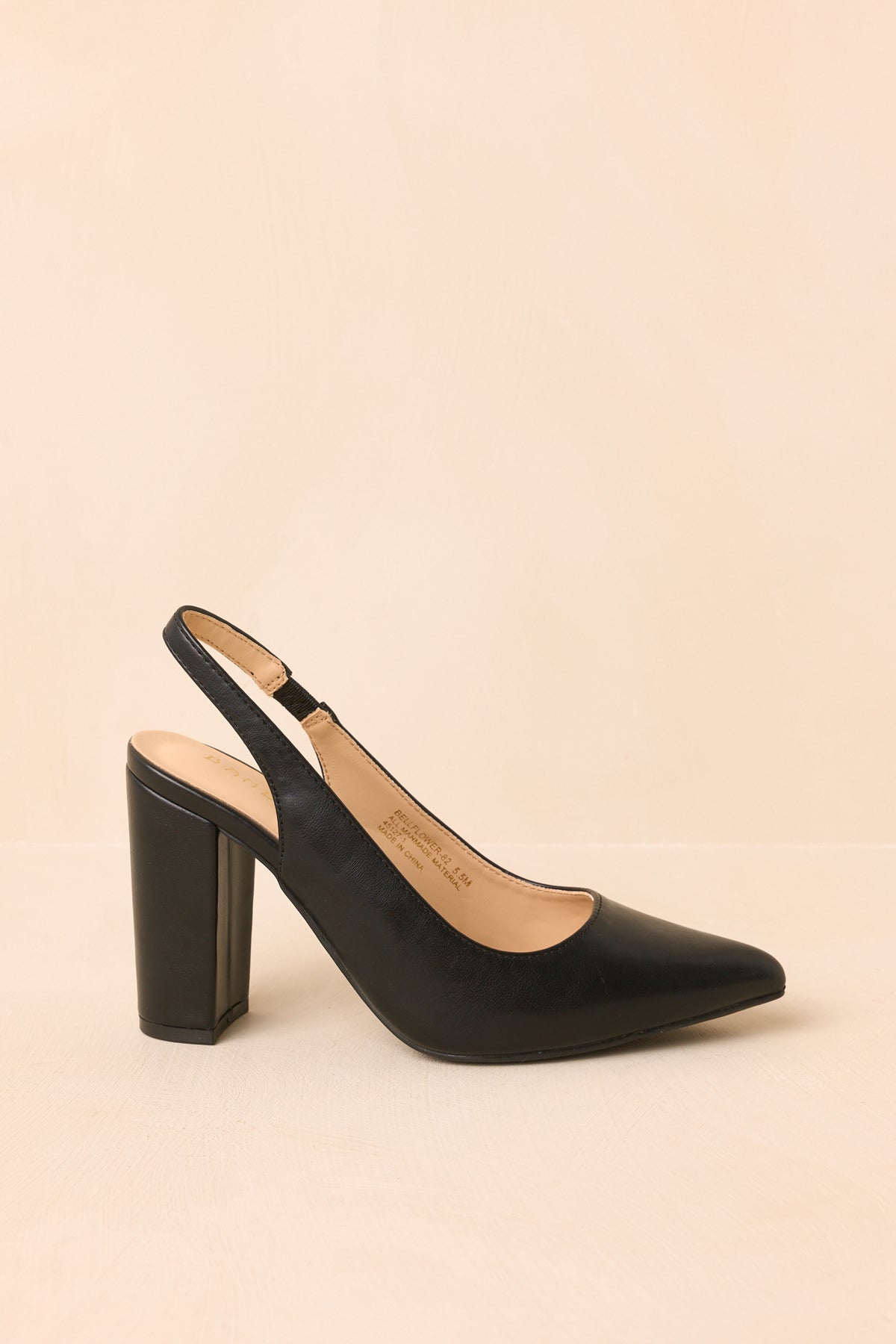Side profile emphasizes the sharp pointed toe, open back, and tall block heel of these black slingbacks.