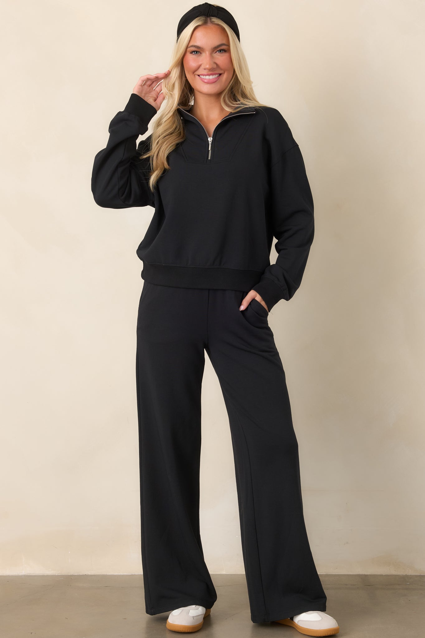 Ultra-soft black sweatshirt featuring a raised stand collar, half-zip front, relaxed silhouette, and ribbed trim along the sleeves and hem.