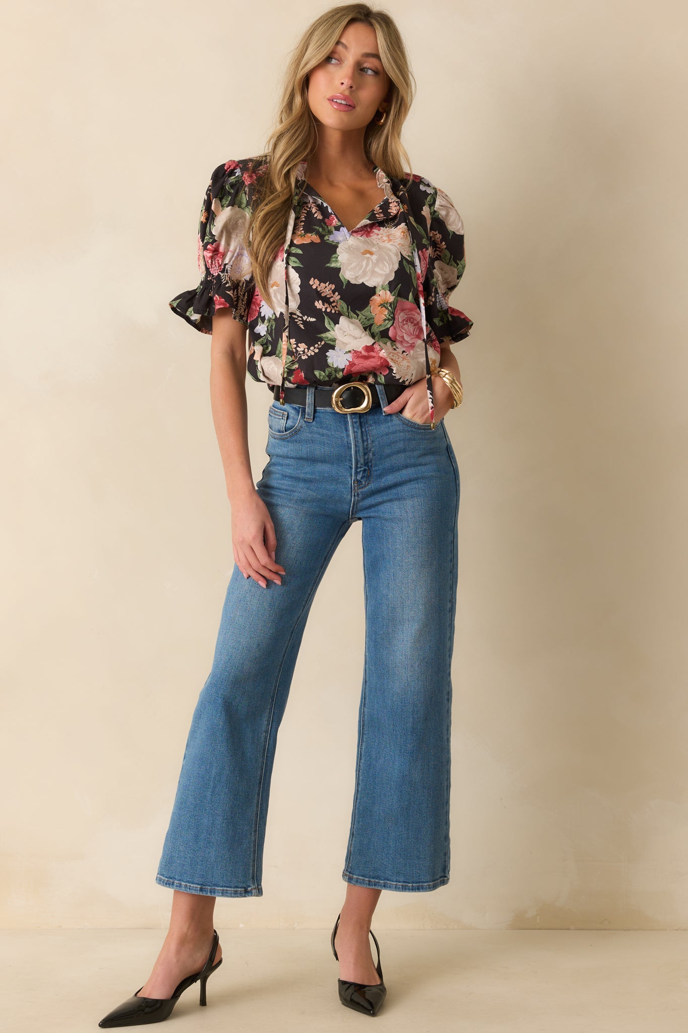 Black top with pink multicolor floral print, split v-neckline, and self-tie tassels.