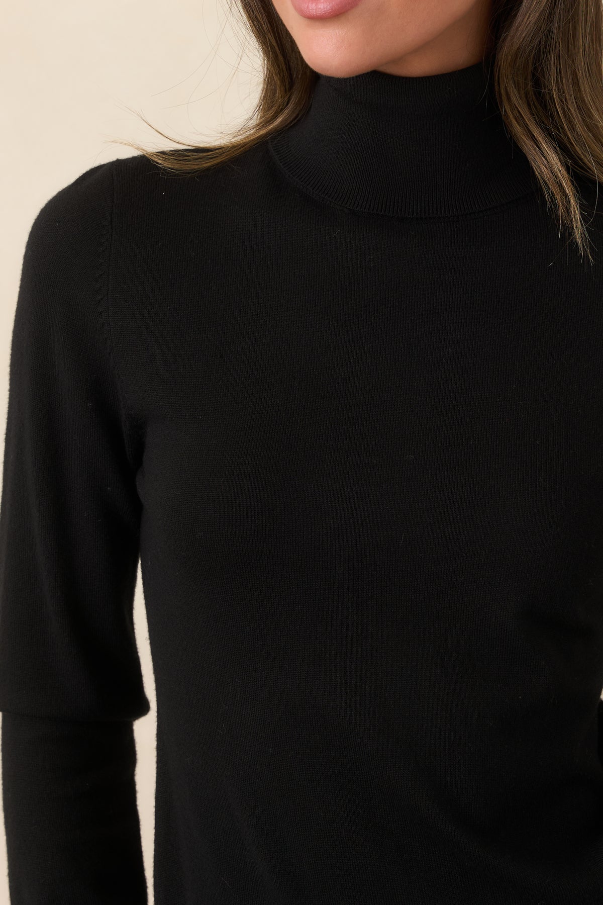 Close-up of the turtleneck and soft knit fabric texture.