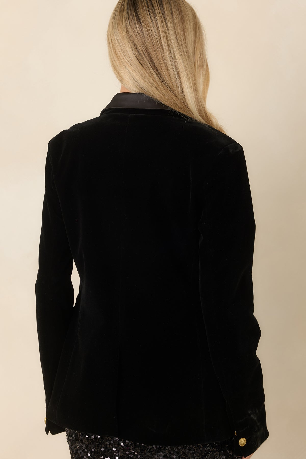 Back of the black velvet blazer featuring a tailored silhouette and long sleeves