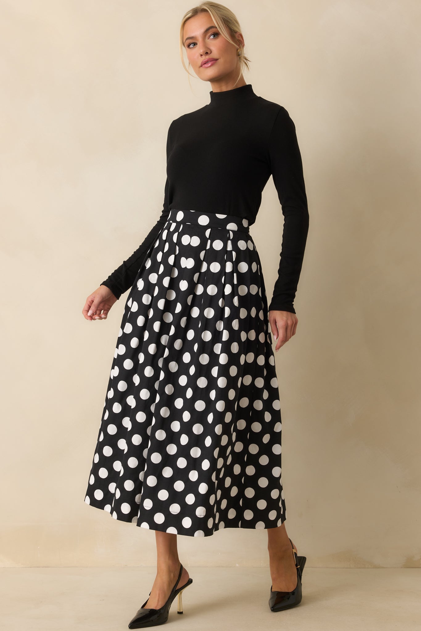 Black and white skirt with a high-rise fit and breezy A-line pleats.