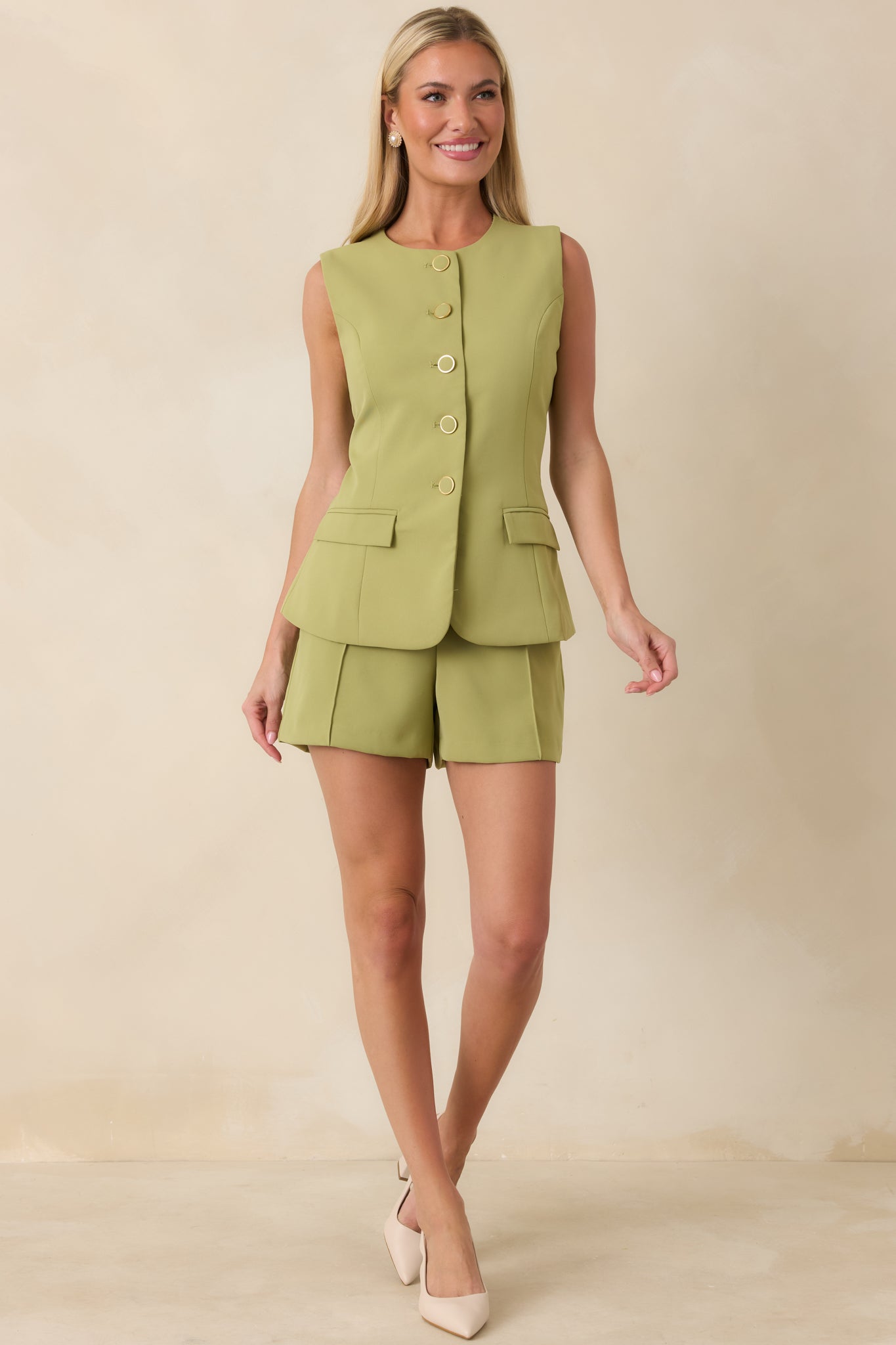 Blazer-inspired green woven top with a clean round neckline, shaping seams, and statement gold-tone ring buttons down the front