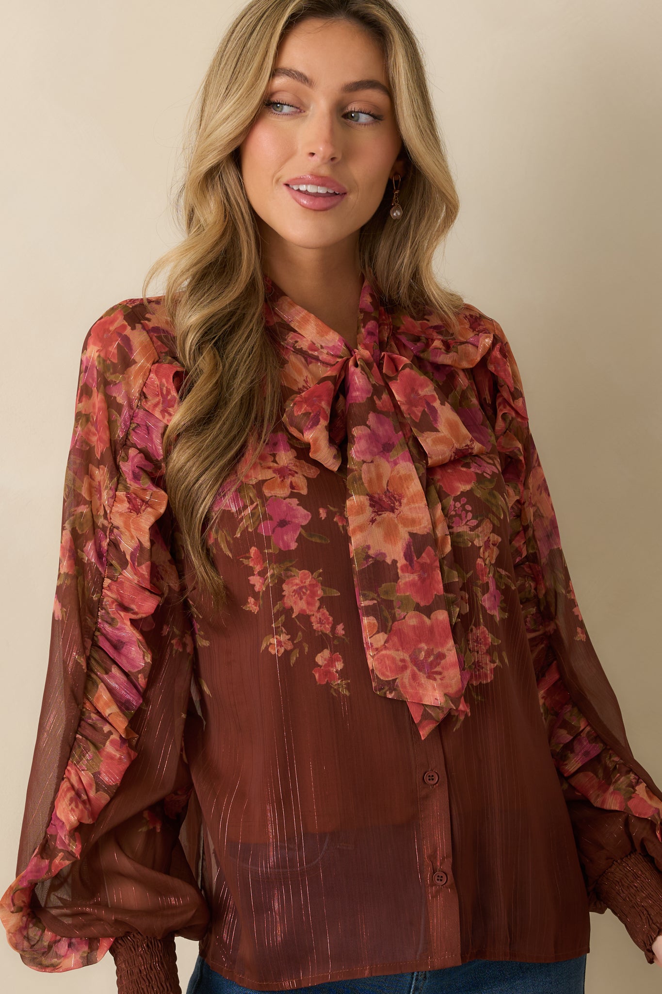 Cropped shot of blouse front focusing on blouson sleeves and delicate floral pattern.