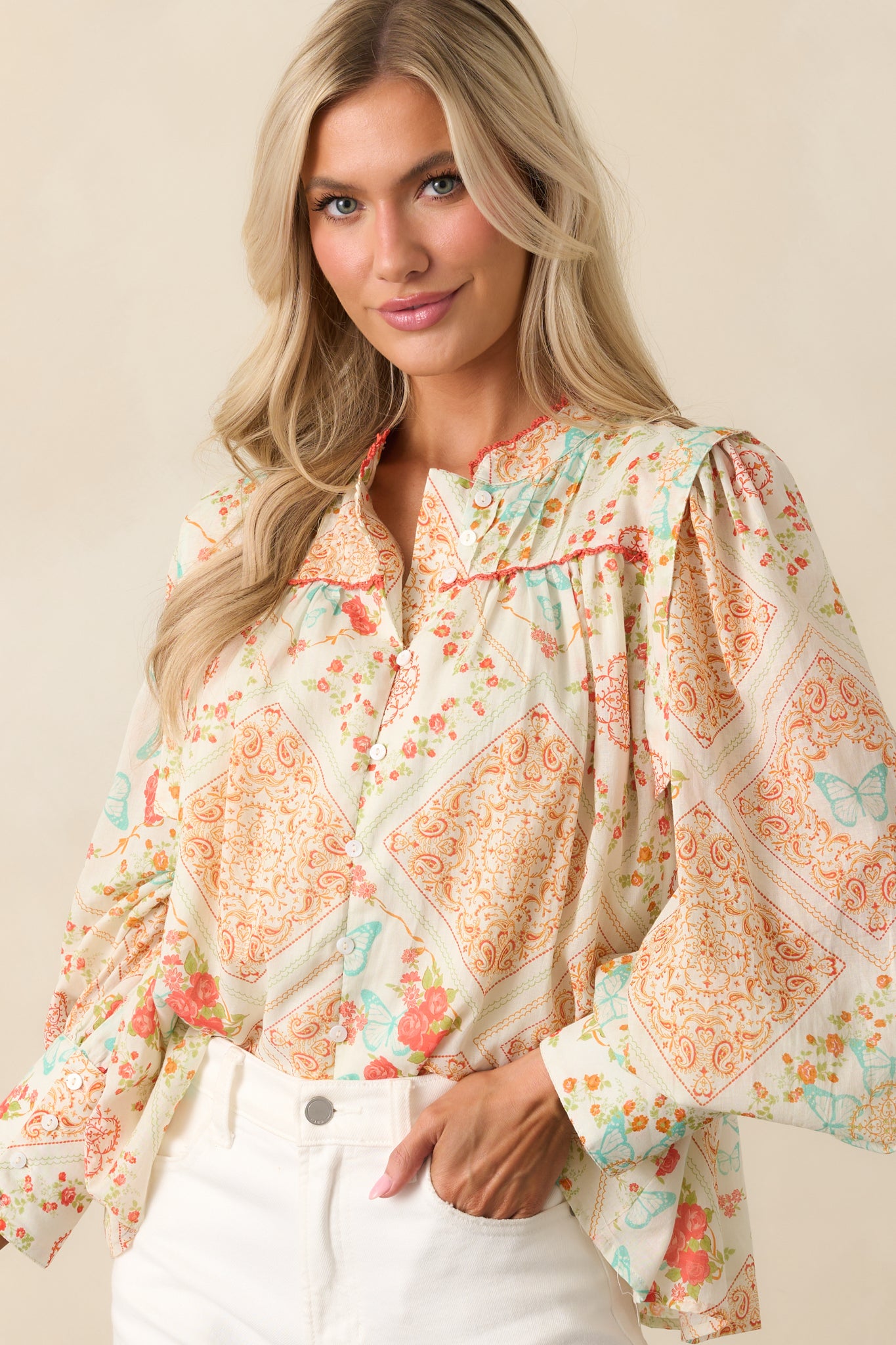 A waist-up cropped image focusing on the pin tuck detailing along the yoke and the floral patchwork print.