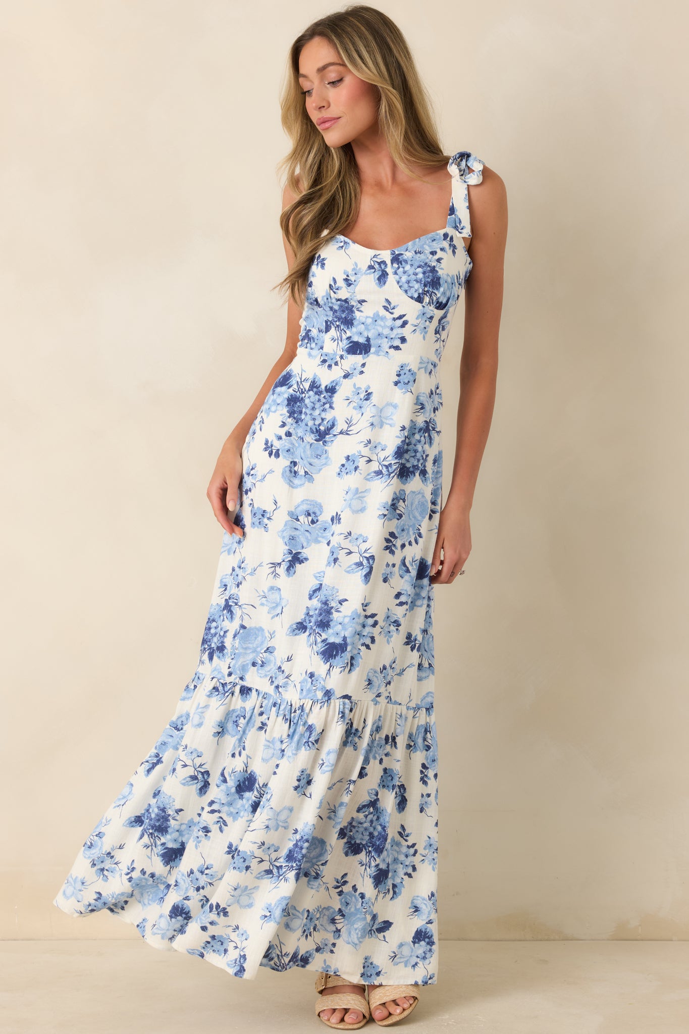 Blue and ivory floral midi dress with adjustable tie straps and airy skirt.
