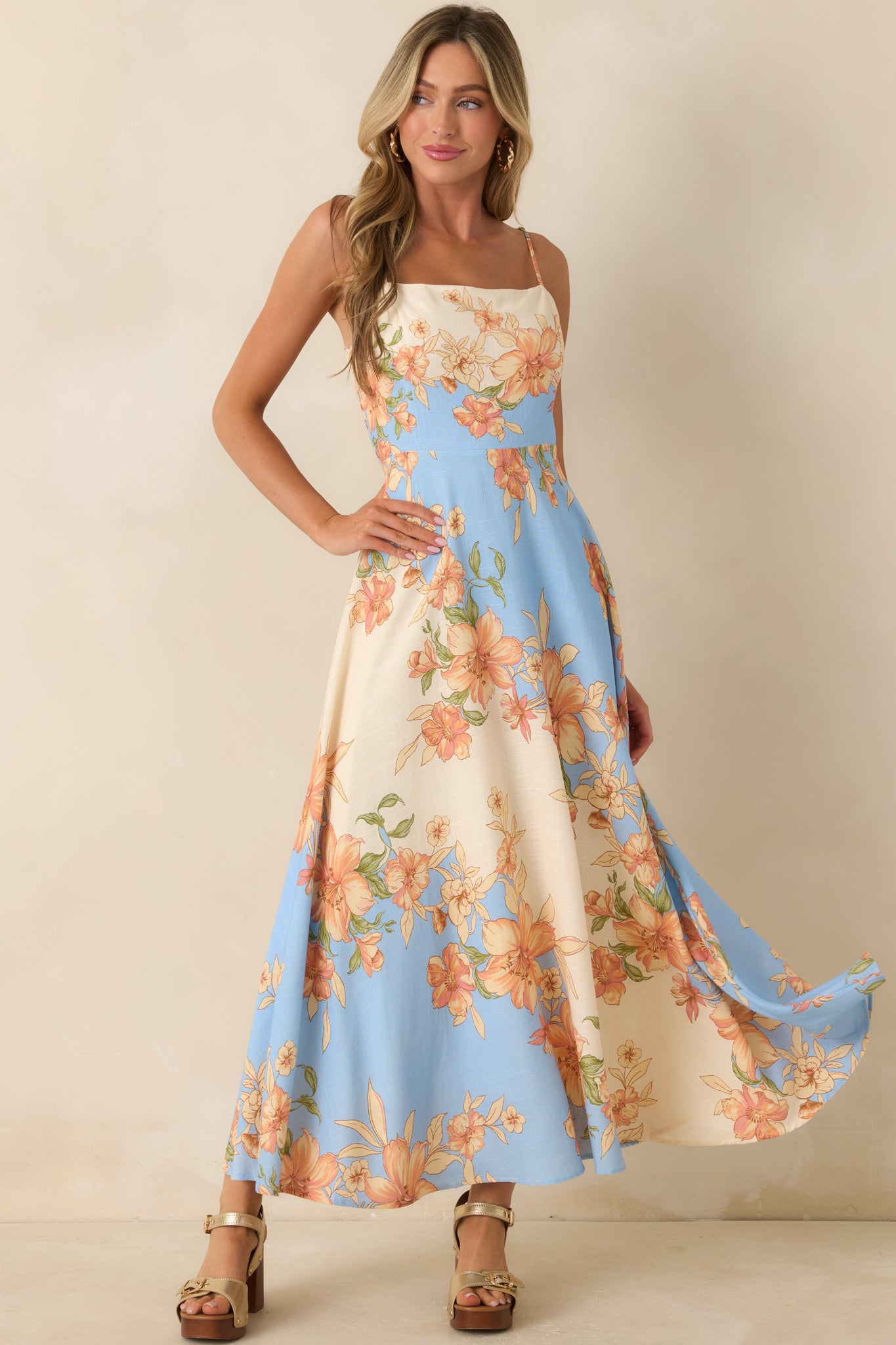 Blue and ivory color-block maxi dress featuring peach and blush floral blooms, a square neckline, and a fitted bodice.