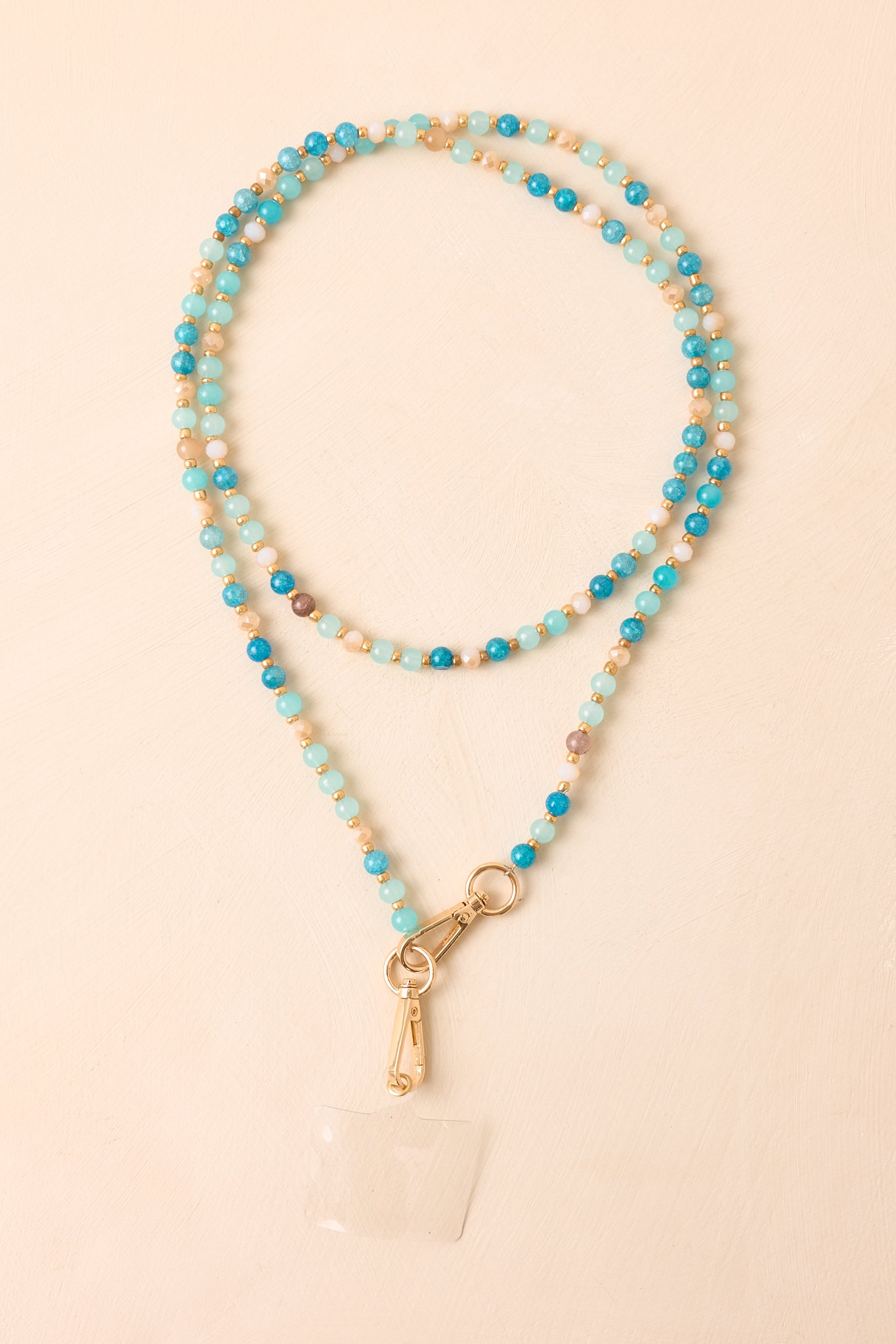 Blue beaded phone lanyard showcasing a mix of smooth beads in coordinating shades with polished gold detailing.