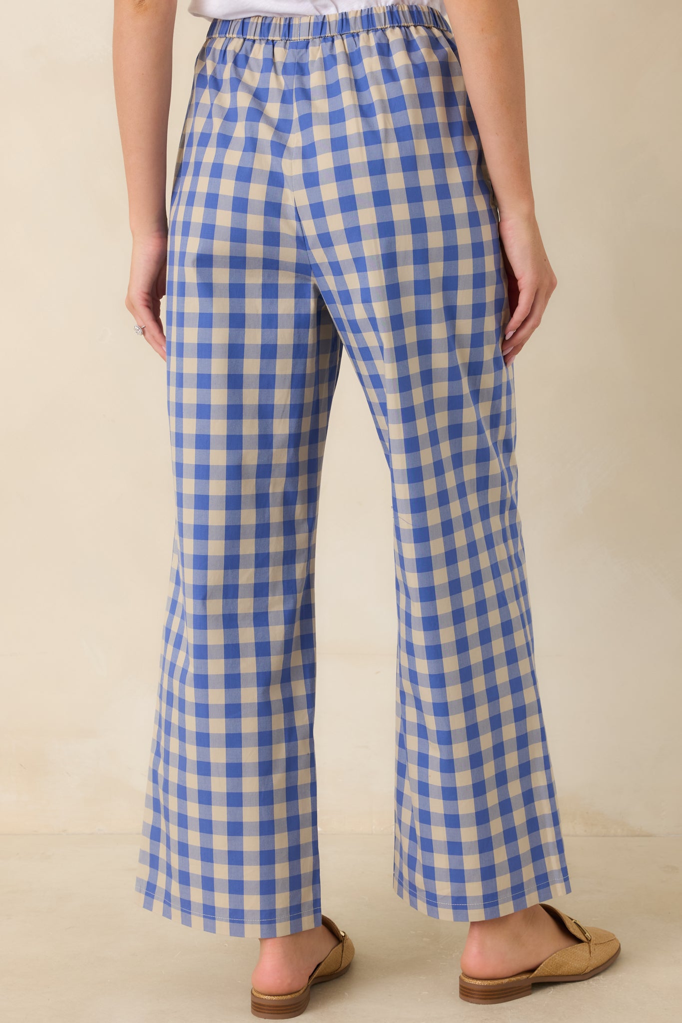 Rear view of the blue and beige gingham cotton pants featuring a relaxed wide leg fit and elastic waistband.