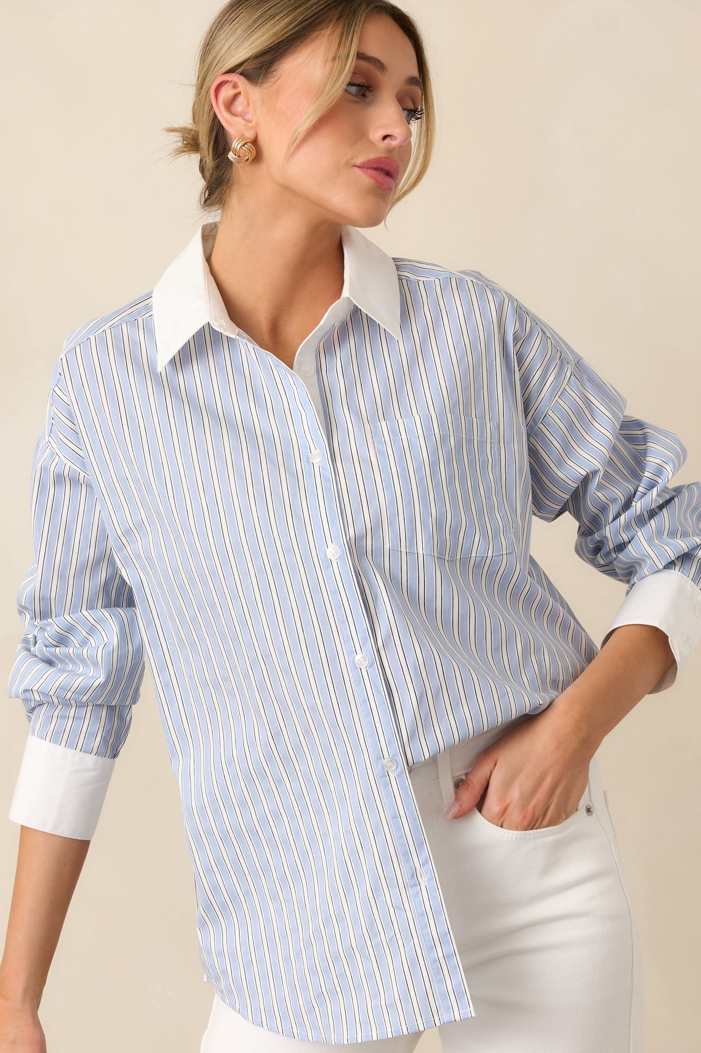 Effortlessly stylish, this blue blouse combines a button front design with long sleeves and white cuffs for a polished look.