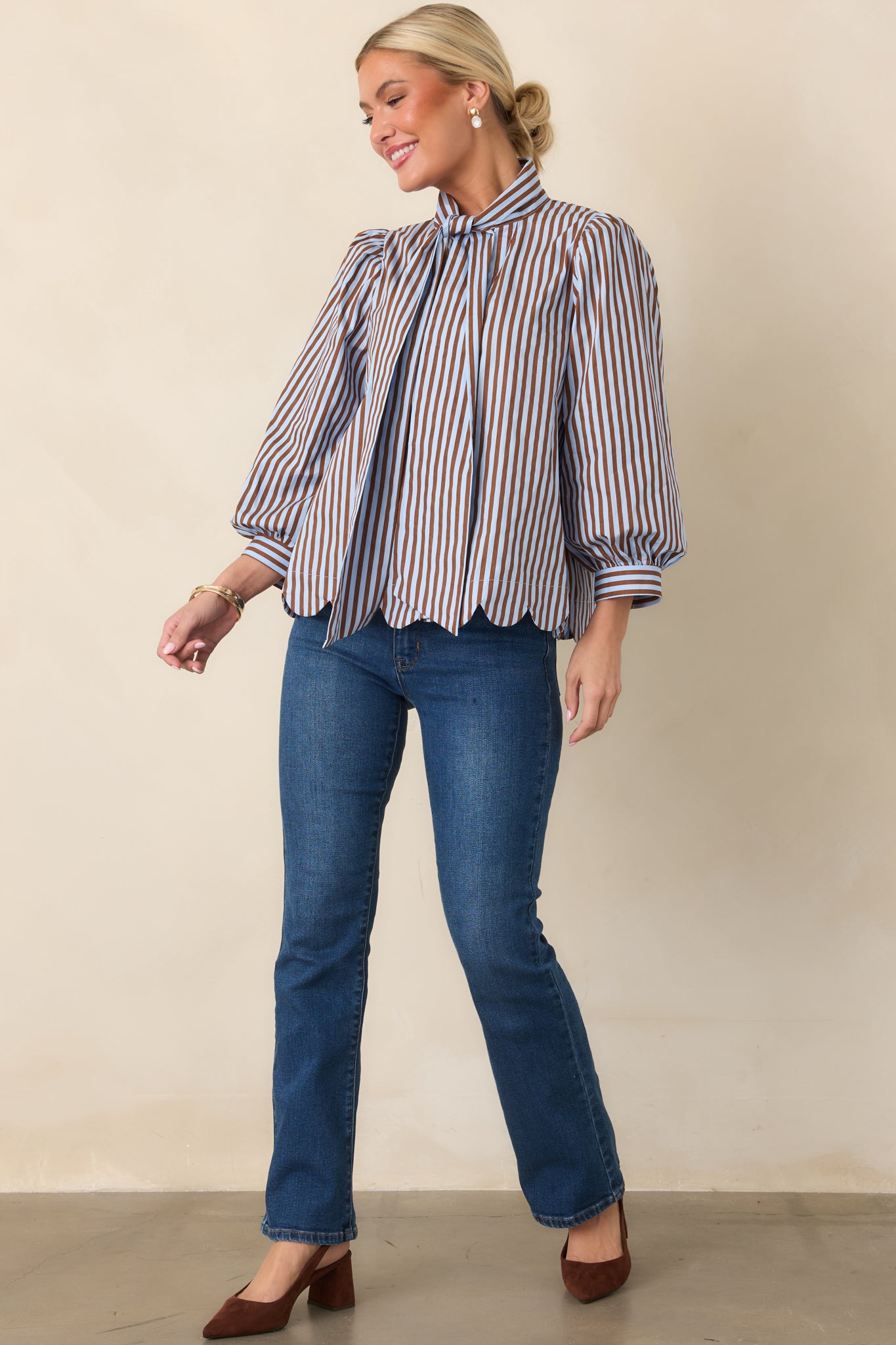 Light blue and dark brown striped blouse with a self-tie neckline, gathered shoulders, and voluminous three-quarter sleeves.