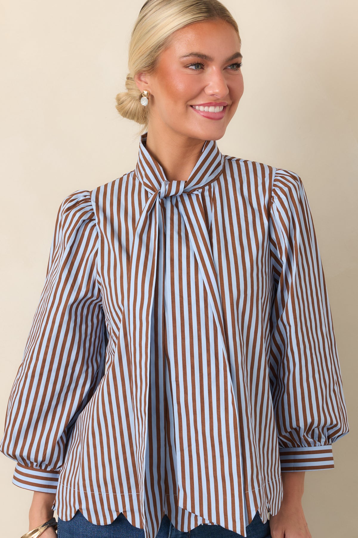 Light blue and dark brown striped blouse highlighting the self-tie neckline and gathered shoulder details.