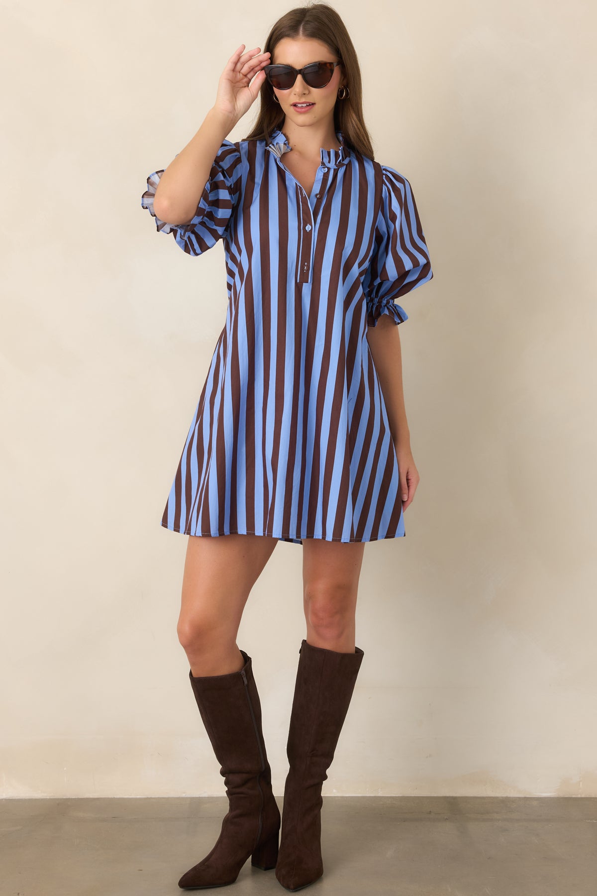 Blue and brown striped shift mini dress showcasing a partial button placket, three-quarter puff sleeves, ruffle-trimmed cuffs, and adjustable tie-back waist detailing.