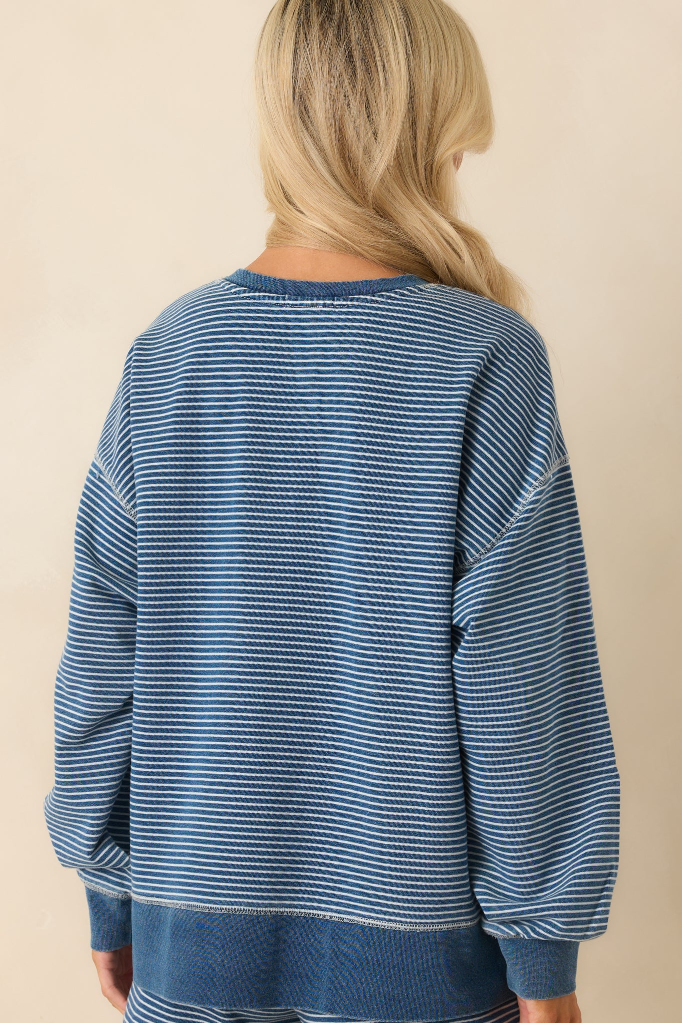 Back view of the sweatshirt showing the continuation of the white stripe pattern and relaxed shape.