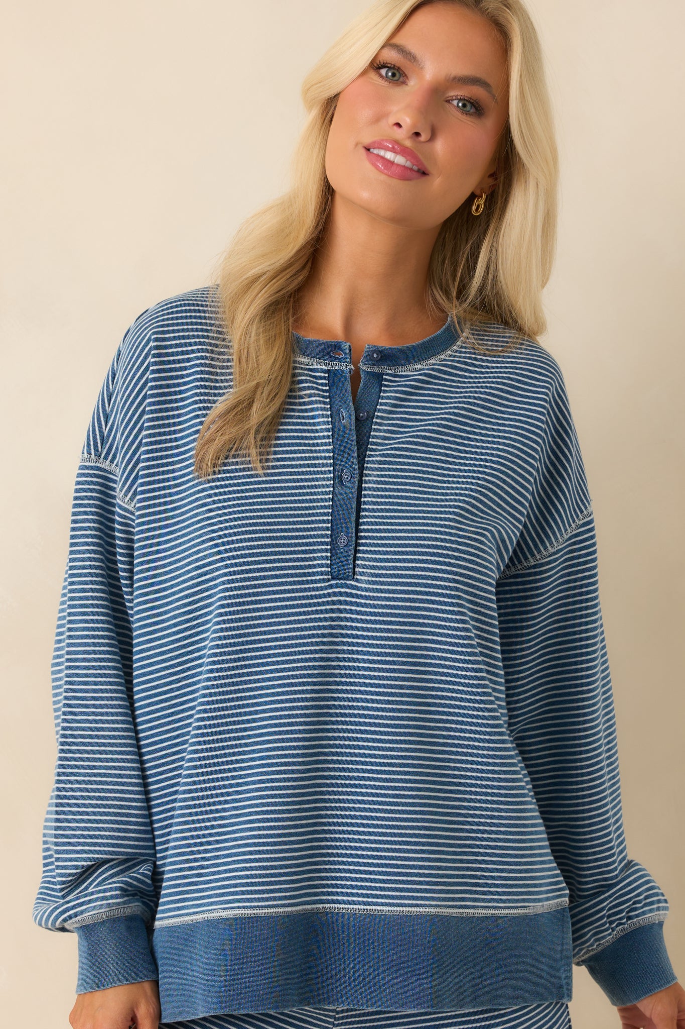 Close crop of the sleeves and shoulder area, emphasizing the drop shoulder seam and white stripe placement.