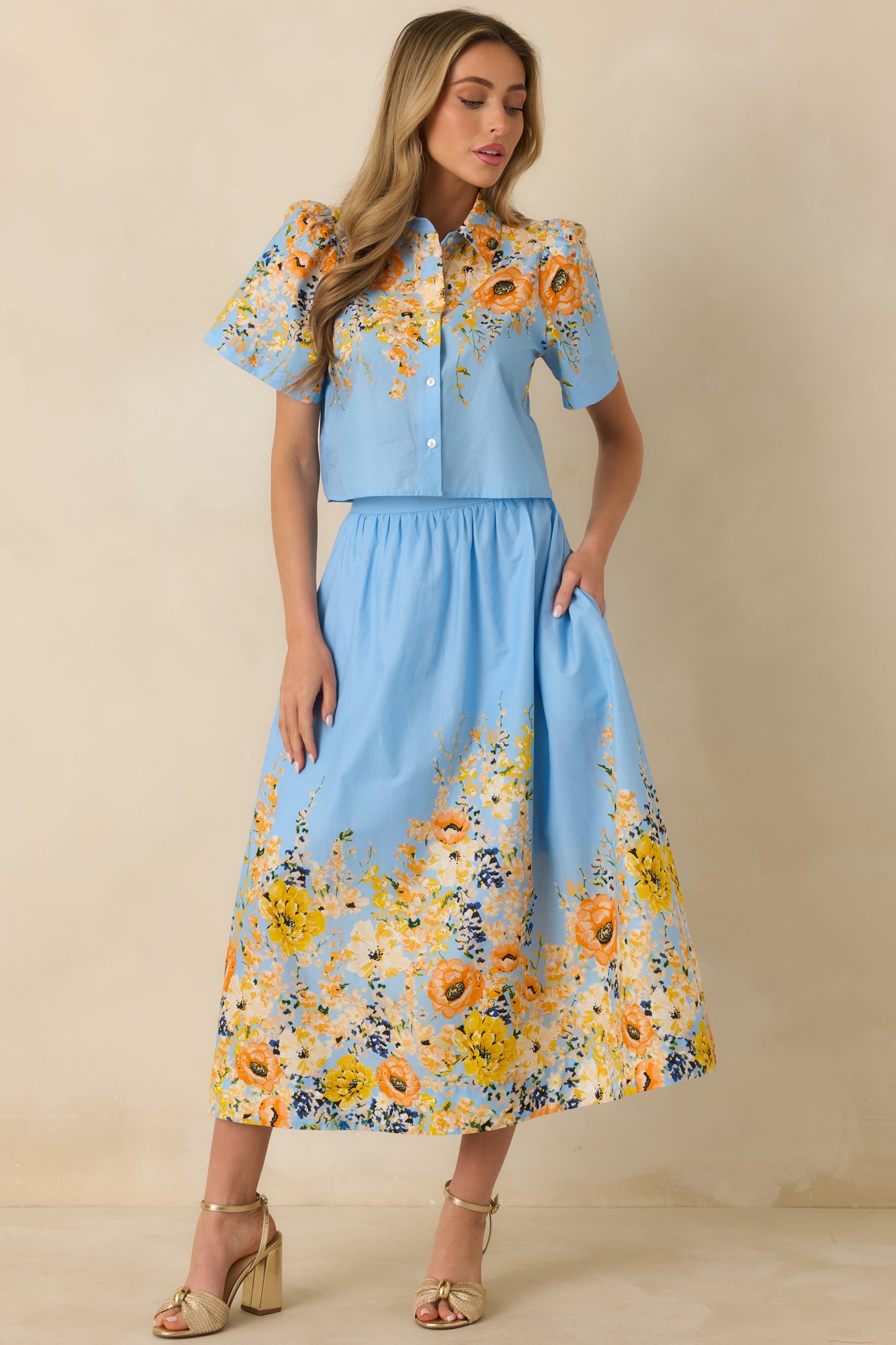Blue cotton maxi skirt designed with a comfortable high-rise fit, airy movement, and floral print detailing at the hem.