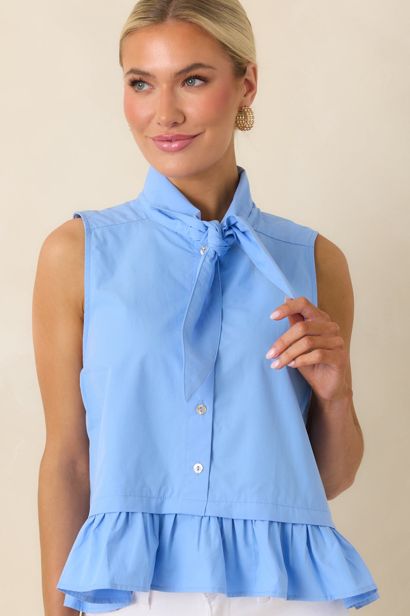 Cropped view of blue cotton top highlighting tie neckline and button front detail