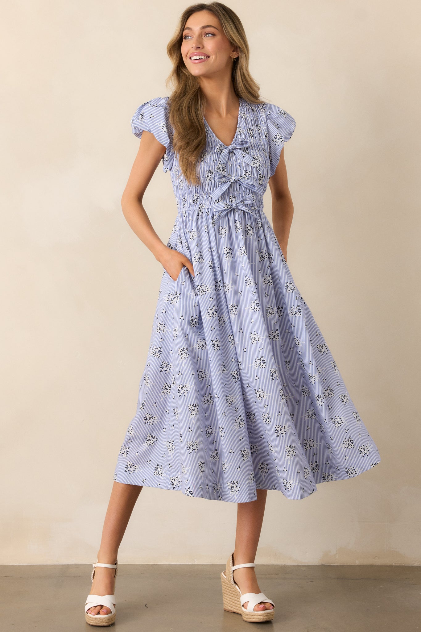 Shot of the blue dress with emphasis on the tiered bow accents and gently flared skirt.