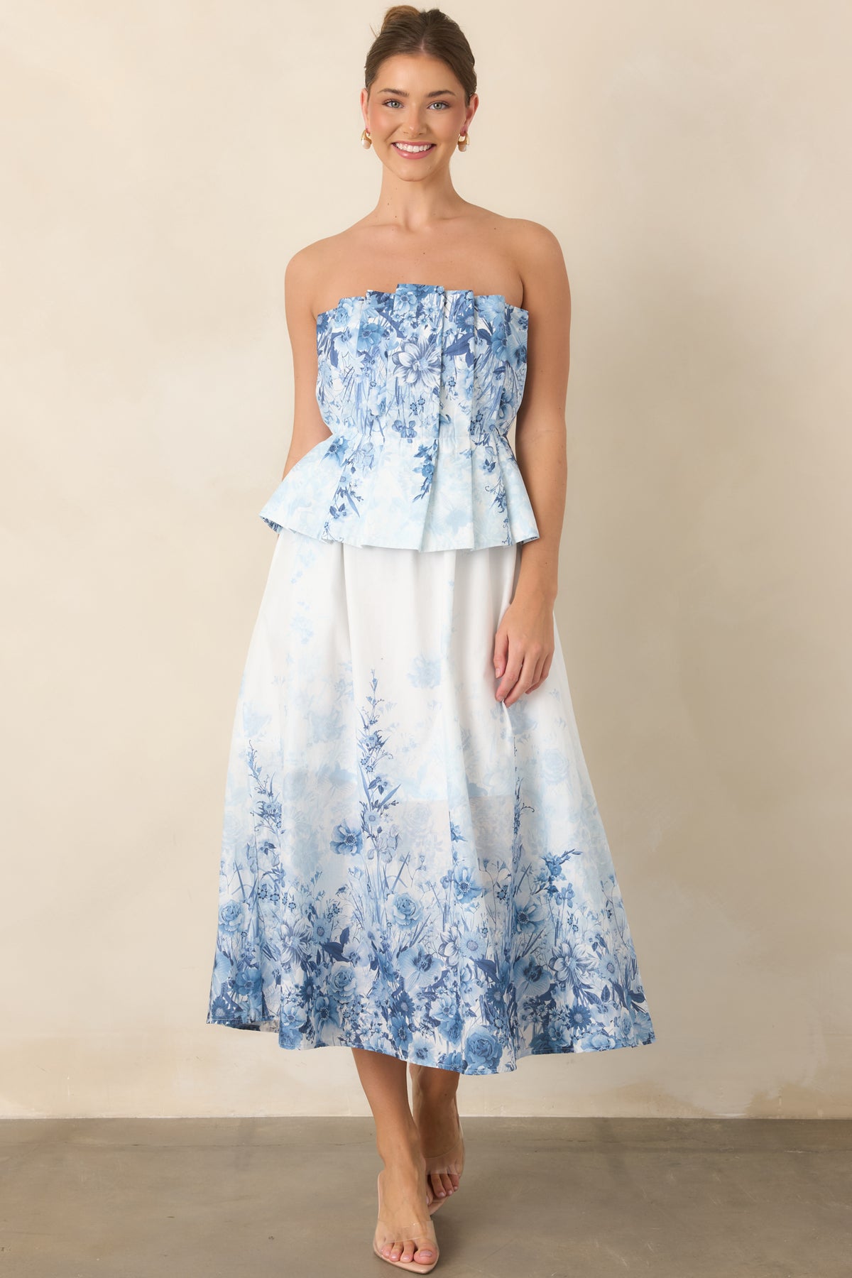 Blue floral cotton dress showcasing the strapless pleated bodice and flowing midi silhouette.