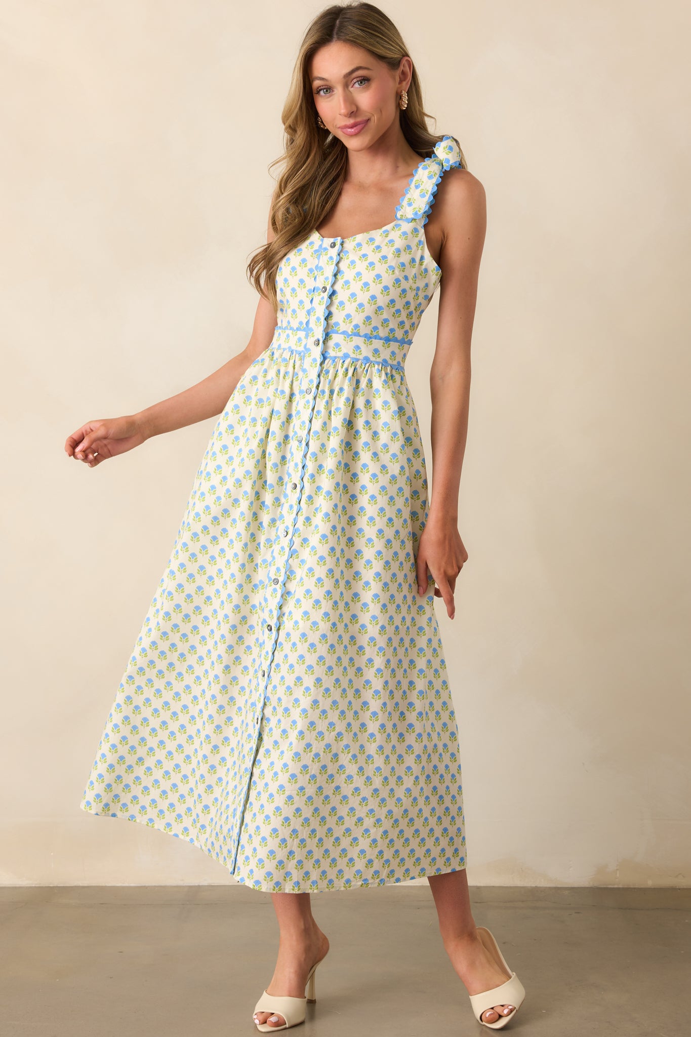 Blue floral dress captured in a full-length view, emphasizing the self-tie straps and flowy, ankle-grazing length.