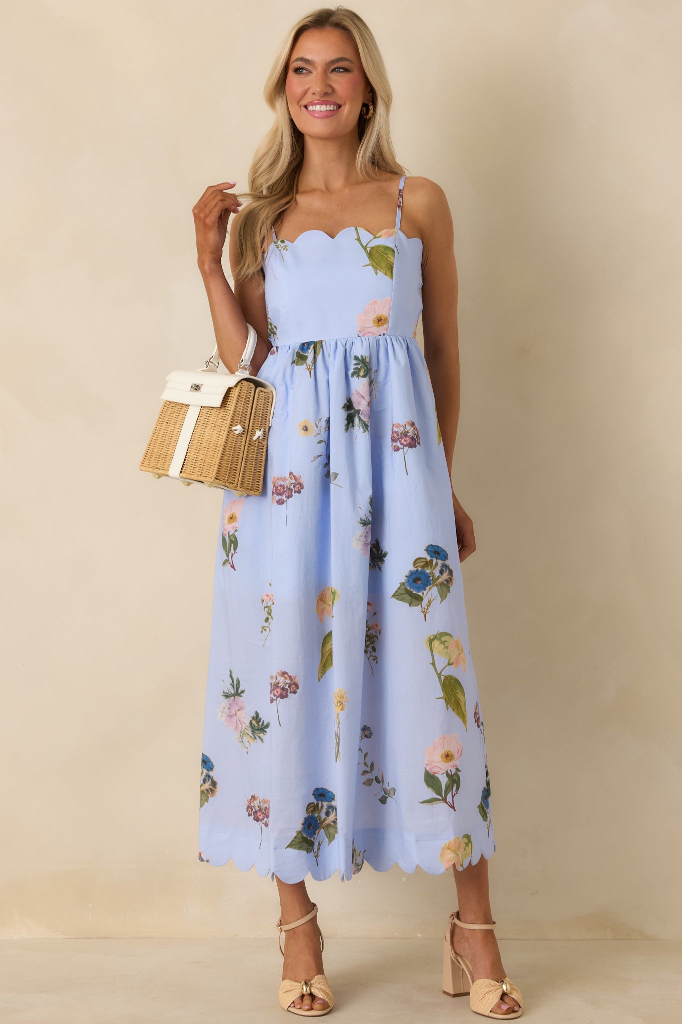 Front view of blue floral midi dress featuring fitted bodice, tie-back detail, and scalloped hem for a flattering shape.