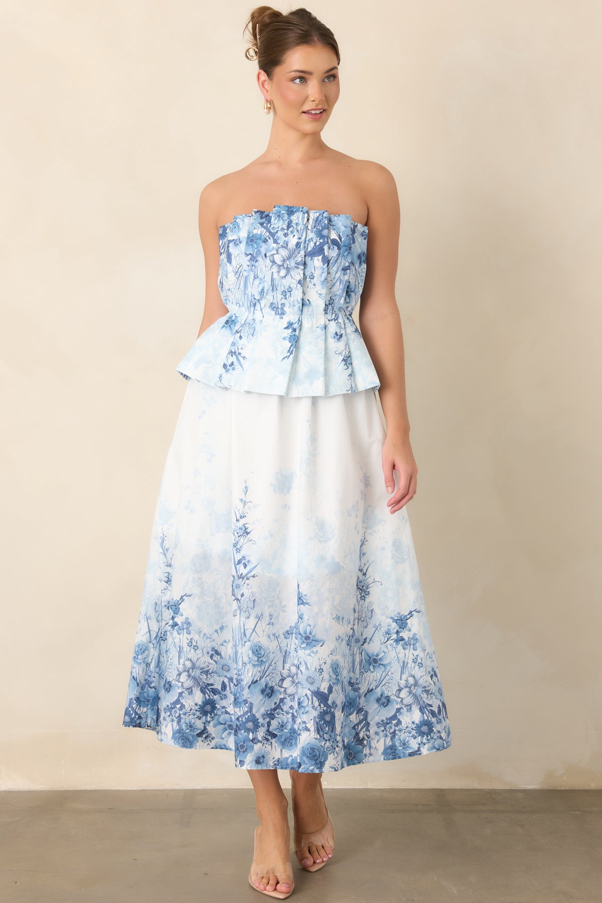Blue floral midi dress featuring a softly pleated strapless bodice and defined waist.