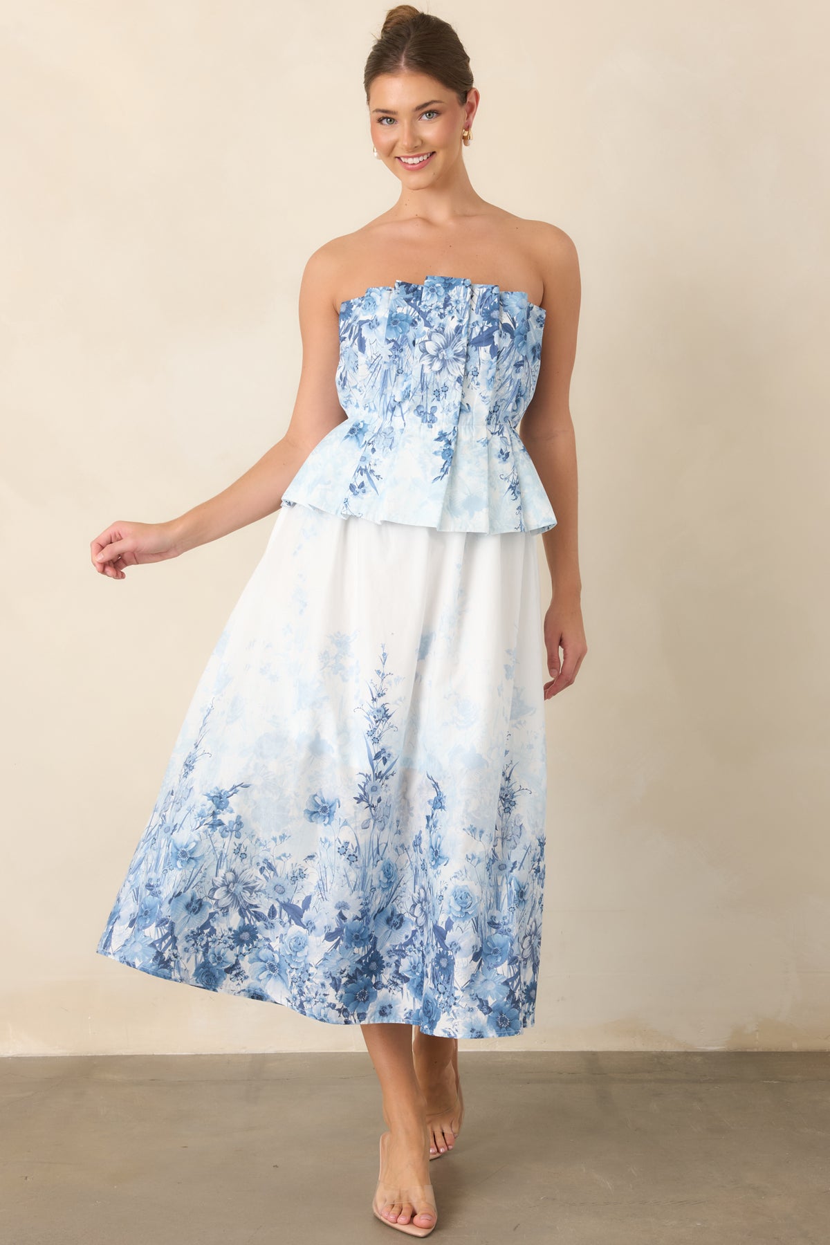 Blue floral midi dress with a structured strapless bodice, elasticized waist, and side pockets.