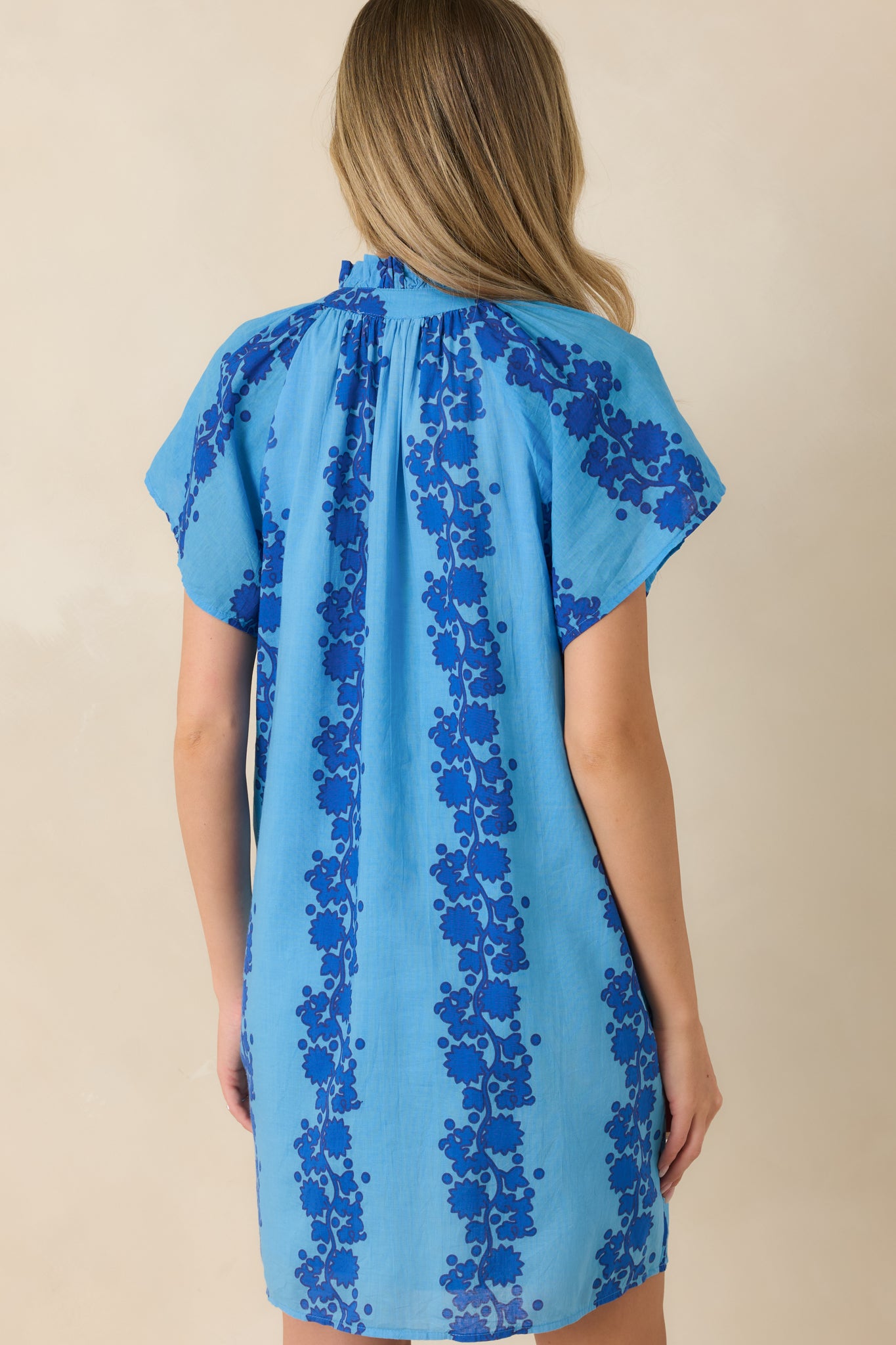 Back view of the blue floral mini dress featuring the relaxed shift silhouette and allover floral print.