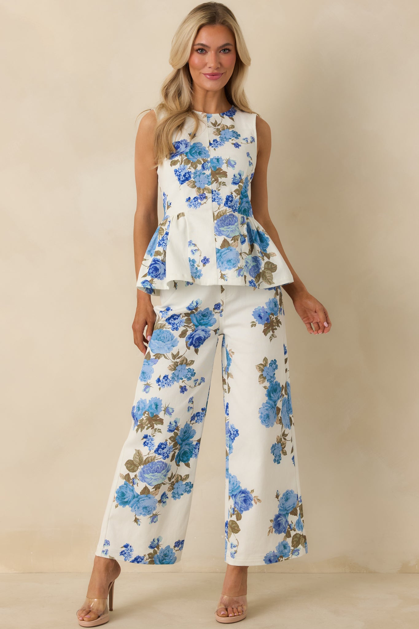 Blue floral print cotton peplum top with a sleeveless design, round neckline, and flared hem.