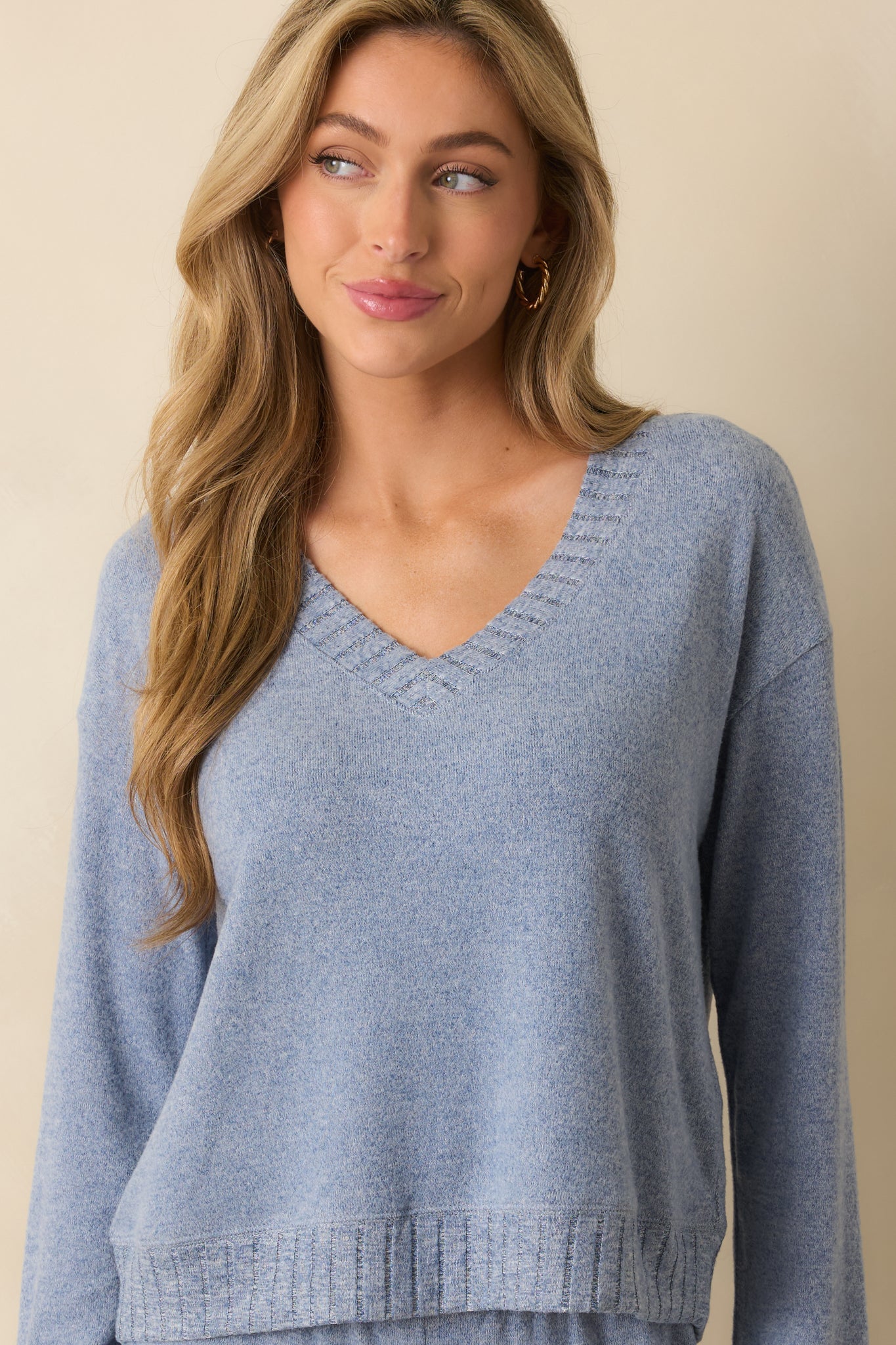 Close crop highlighting soft plush knit texture and relaxed shoulder seam of the sweater.