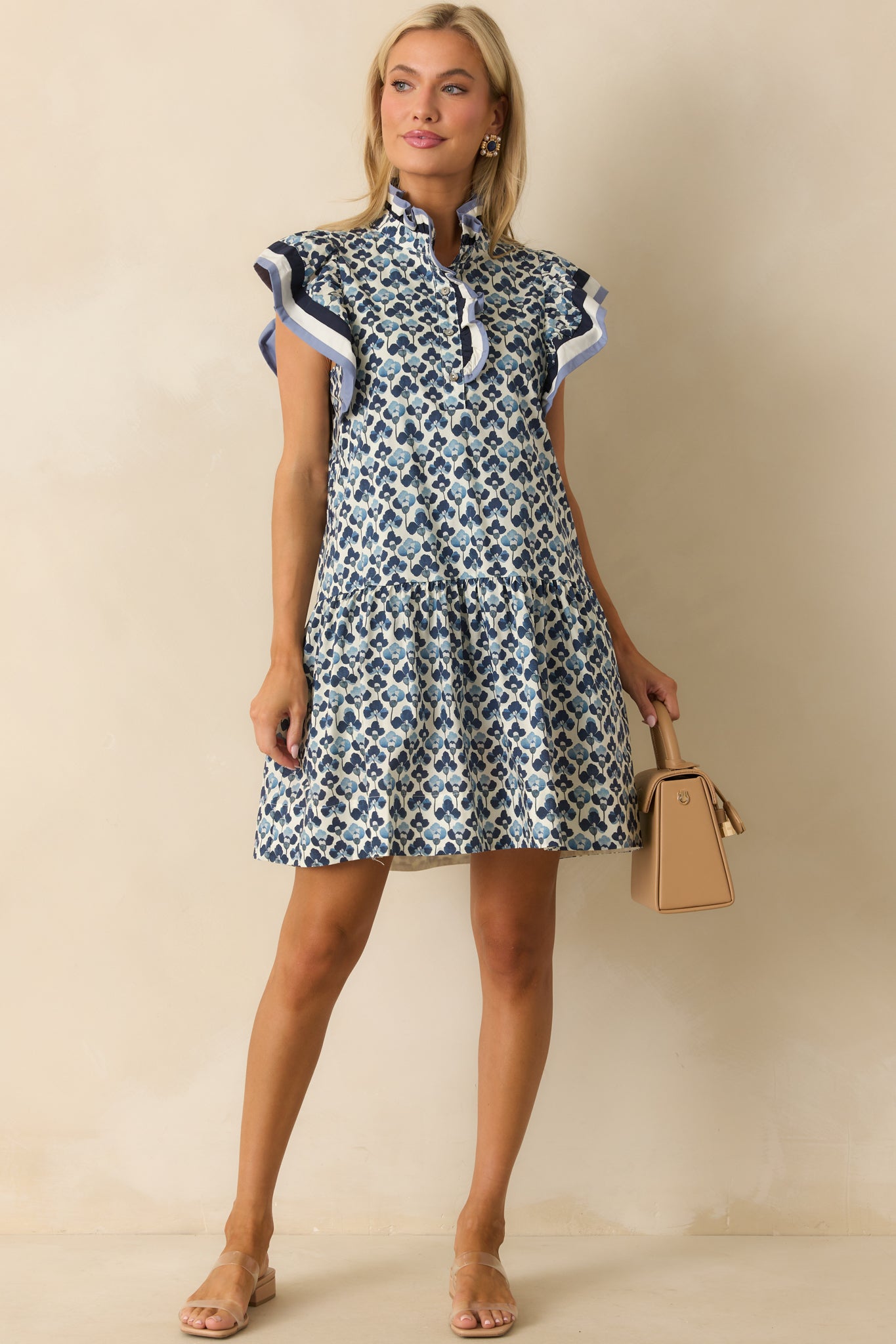 Blue multi floral mini dress displayed front facing, emphasizing the ruffle neckline and mini length.