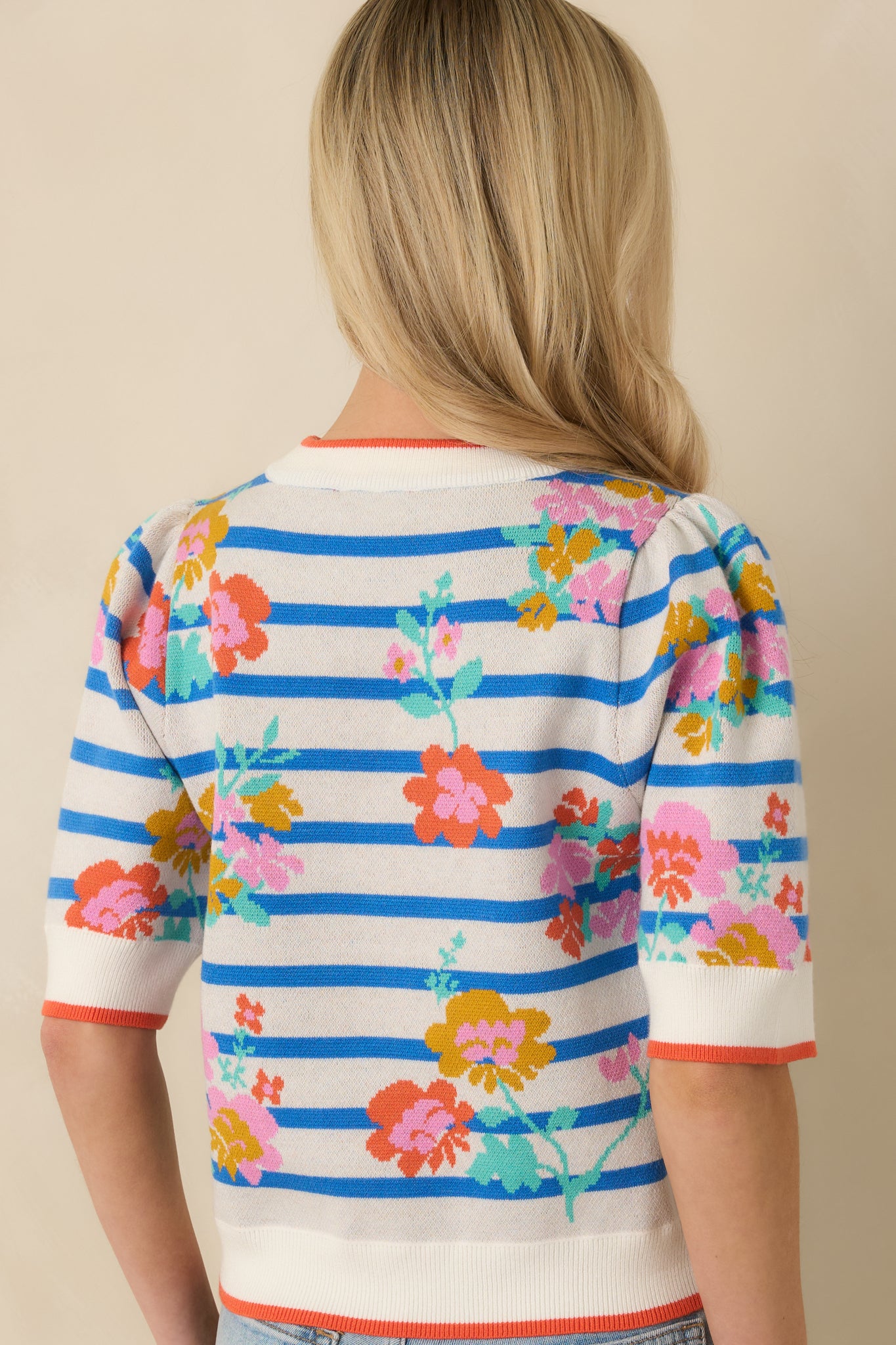 Back view of the blue multi short sleeve sweater highlighting the straight fit, short sleeves, and striped floral knit pattern.