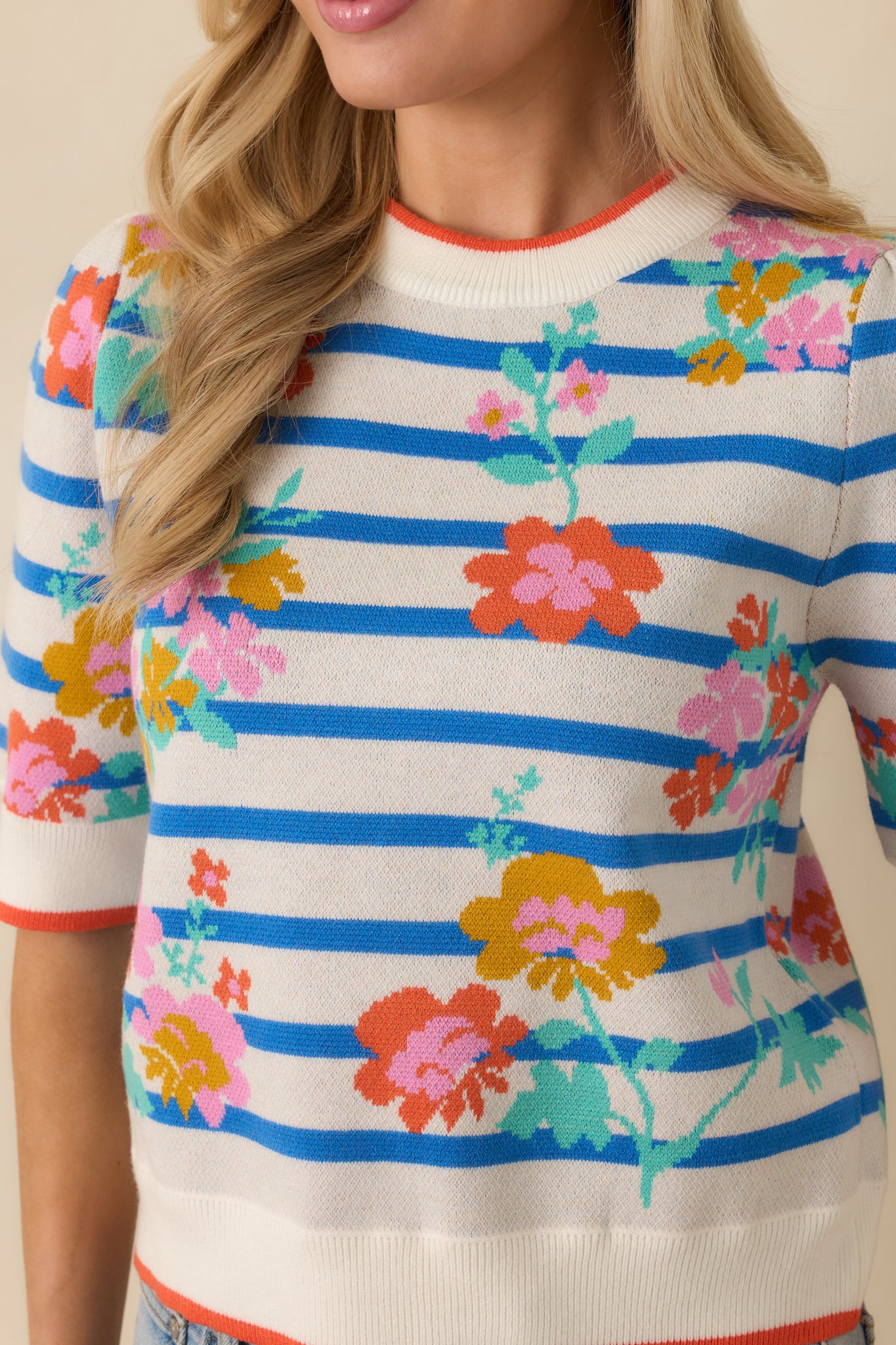 Close-up of the blue multi short sleeve sweater showing the colorful floral knit pattern and contrast trim.