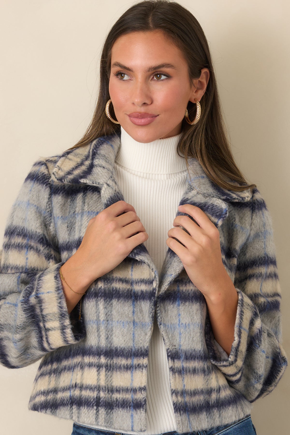 Blue, navy, and ivory plaid jacket featuring a boxy cropped fit, oversized notched lapels, and wide cuffs.