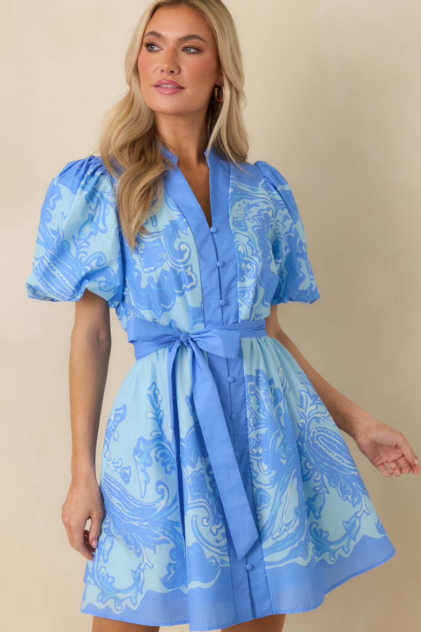 Blue paisley mini dress detail emphasizing the removable self-tie belt and defined waistline.