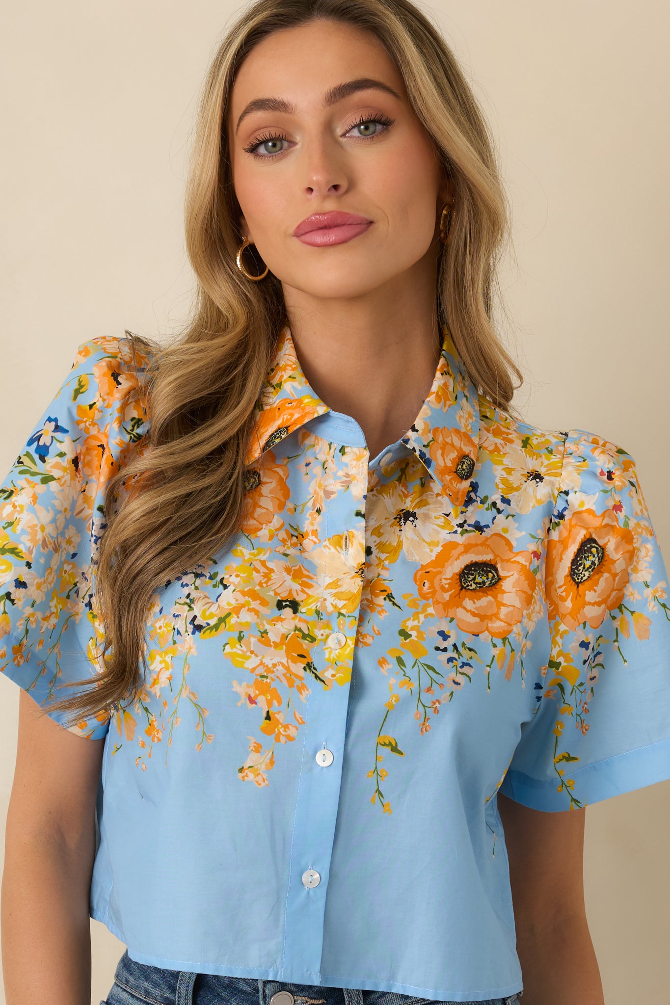 Blue short sleeve top showing the structured collar and smooth button placket.