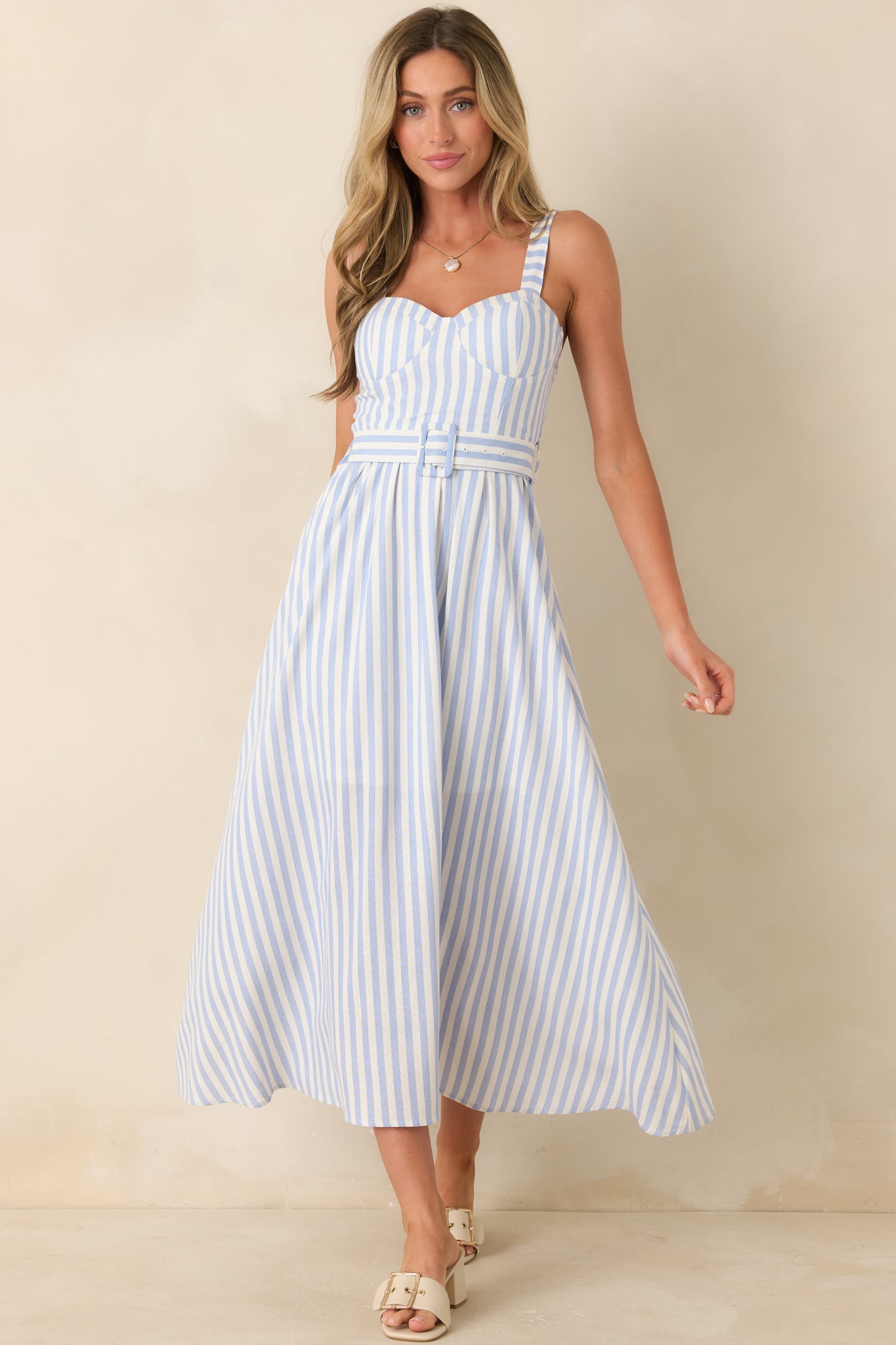 Blue stripe midi dress with a belted waist, structured bodice, and lightweight flowing skirt design.