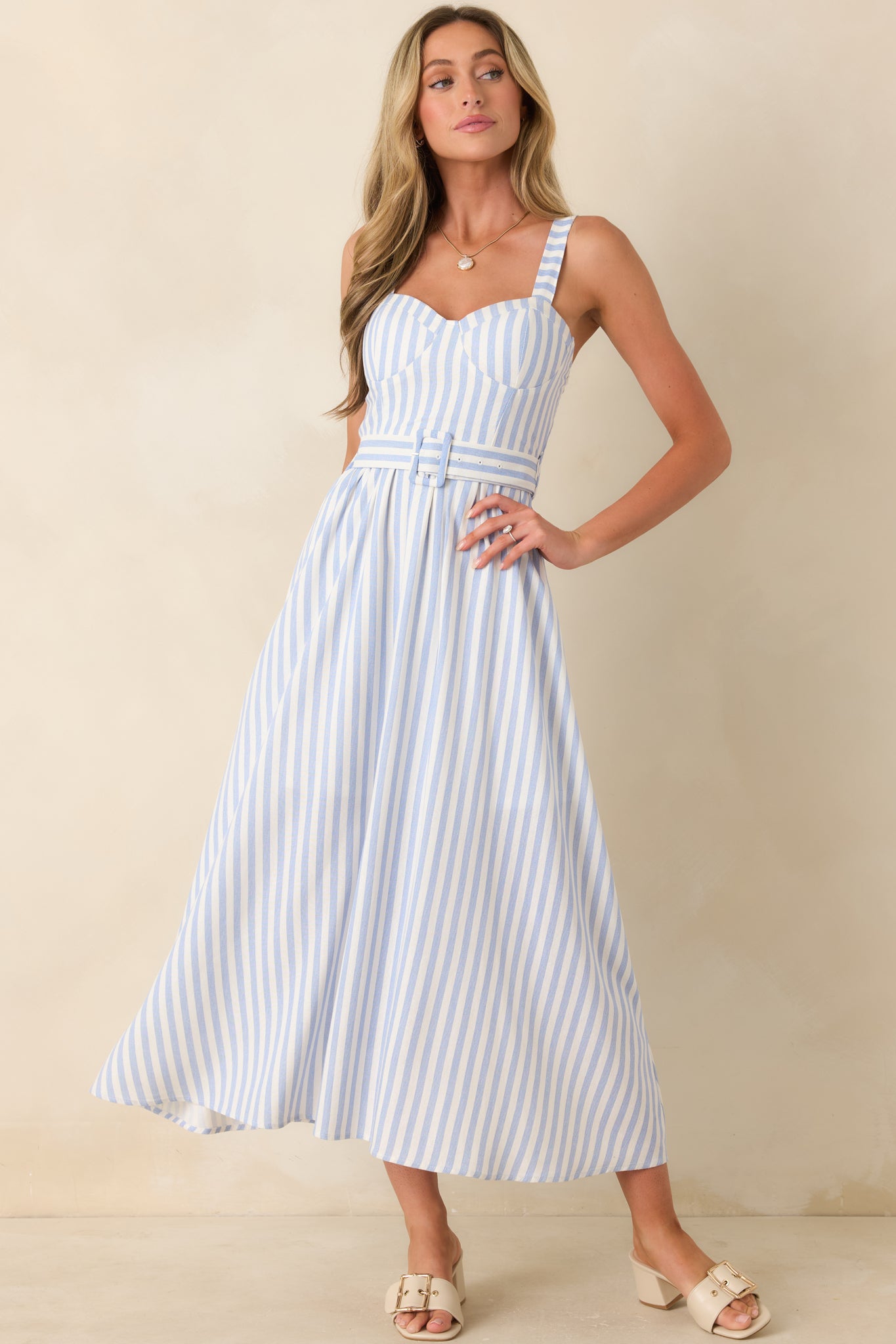 Blue stripe midi dress highlighting the smocked waist detail, structured bodice, and soft flowing skirt.