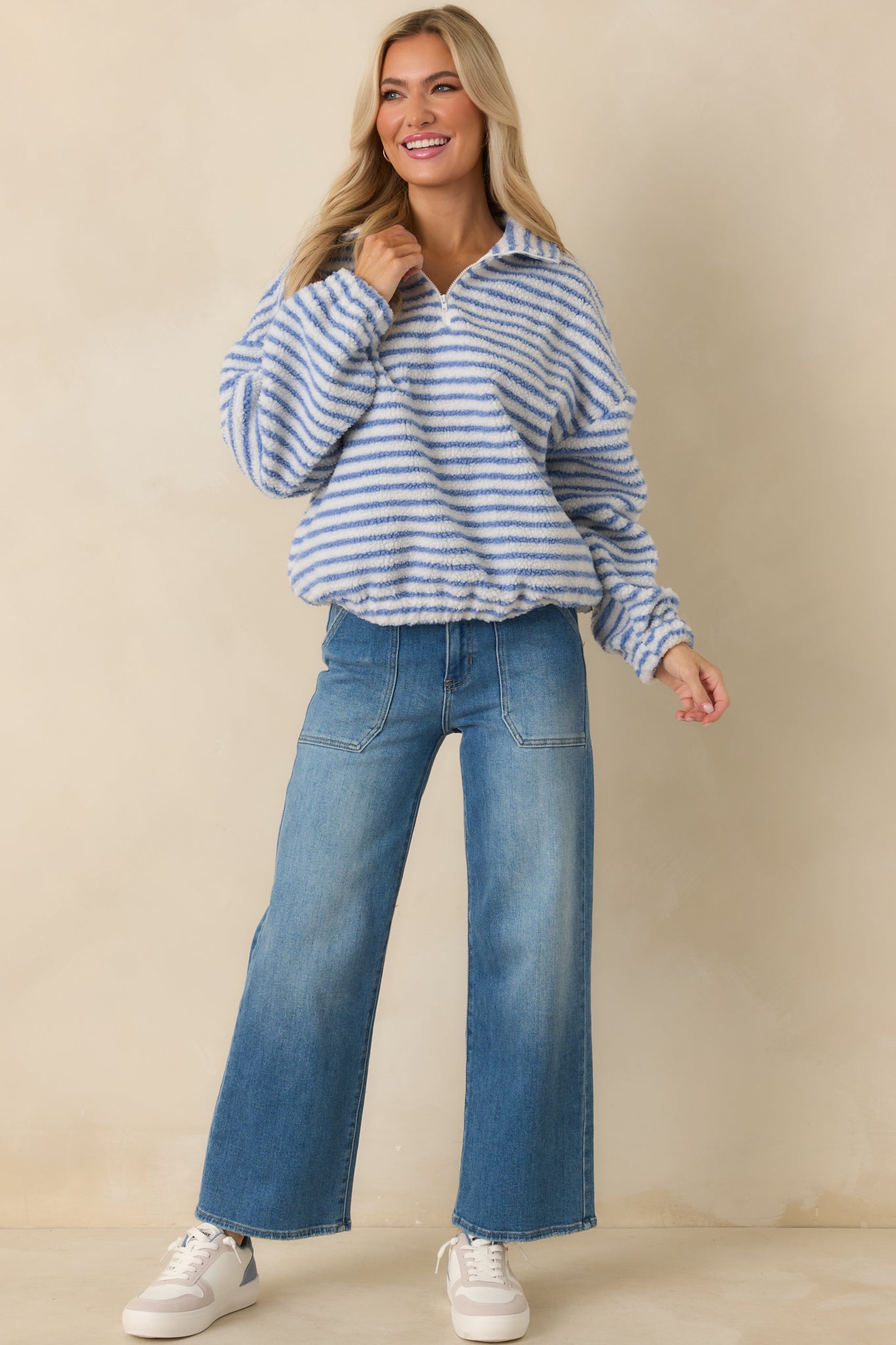 Full-length image of blue stripe quarter-zip sweatshirt with easy oversized silhouette and straight hem.