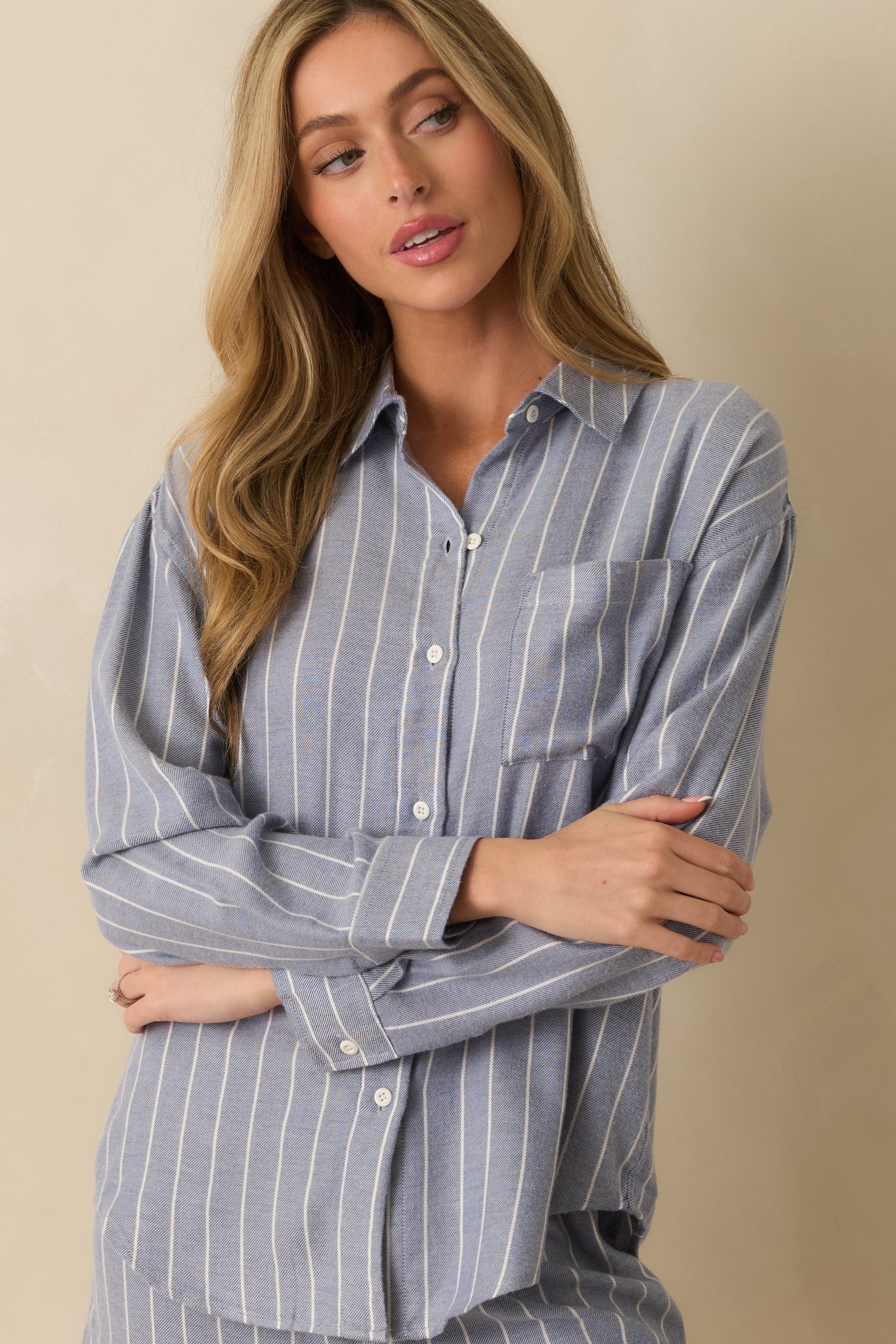 Detail view of single chest pocket and knit fabric texture in blue stripes.