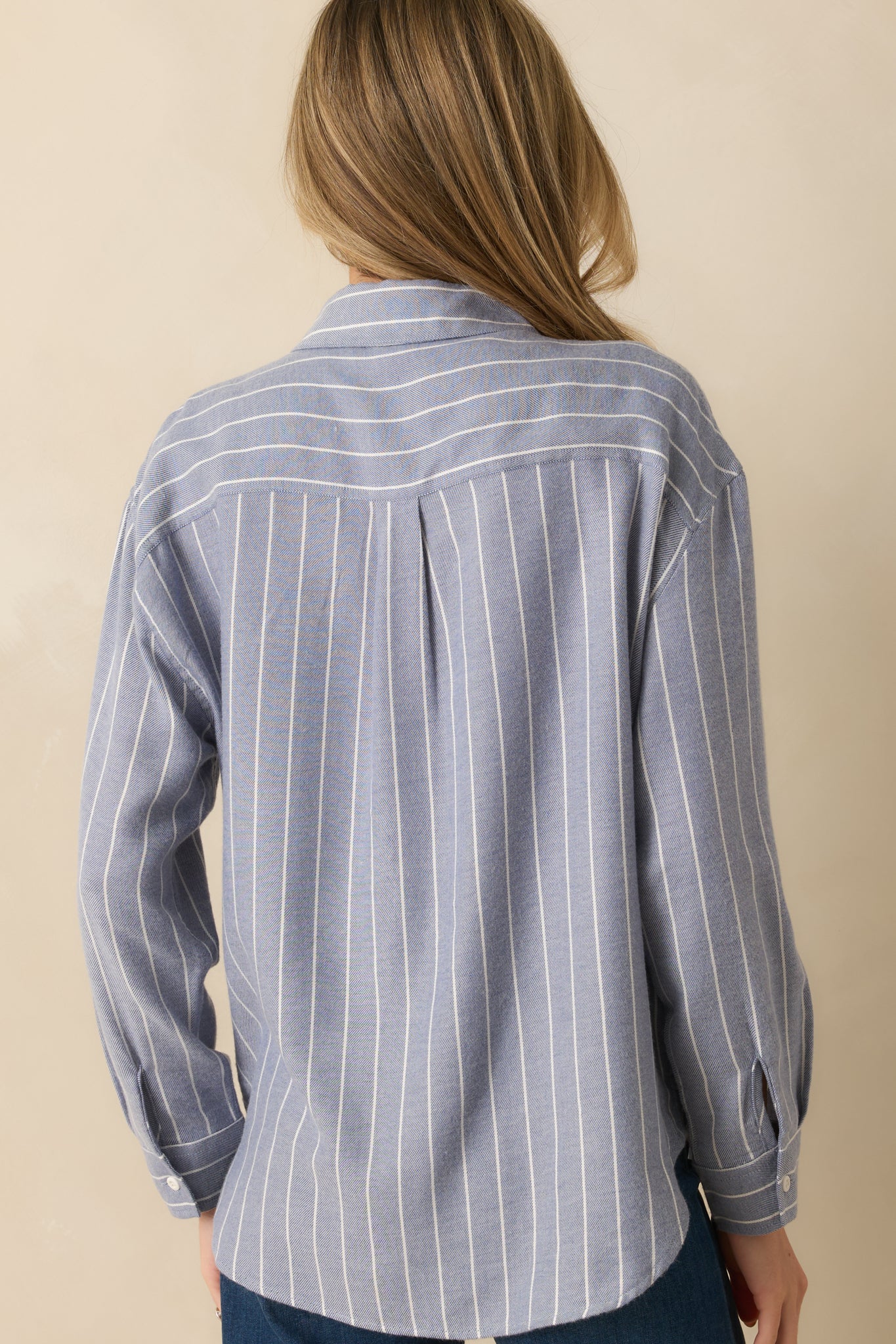 Rear view of blue striped shirt showing relaxed fit, long sleeves, and smooth knit fabric.