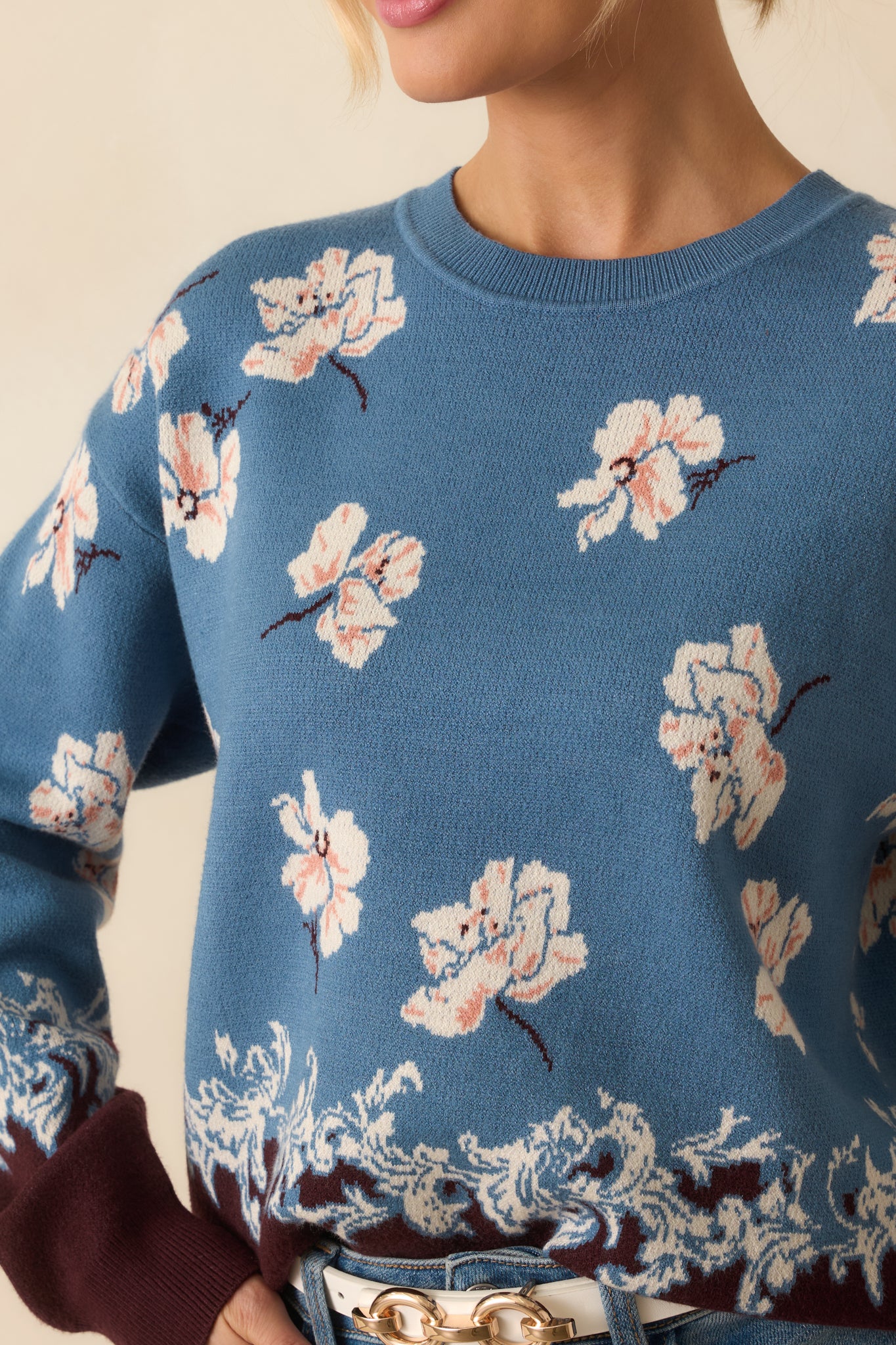 Zoomed-in view of the ivory floral jacquard design and brown contrast border with visible knit texture