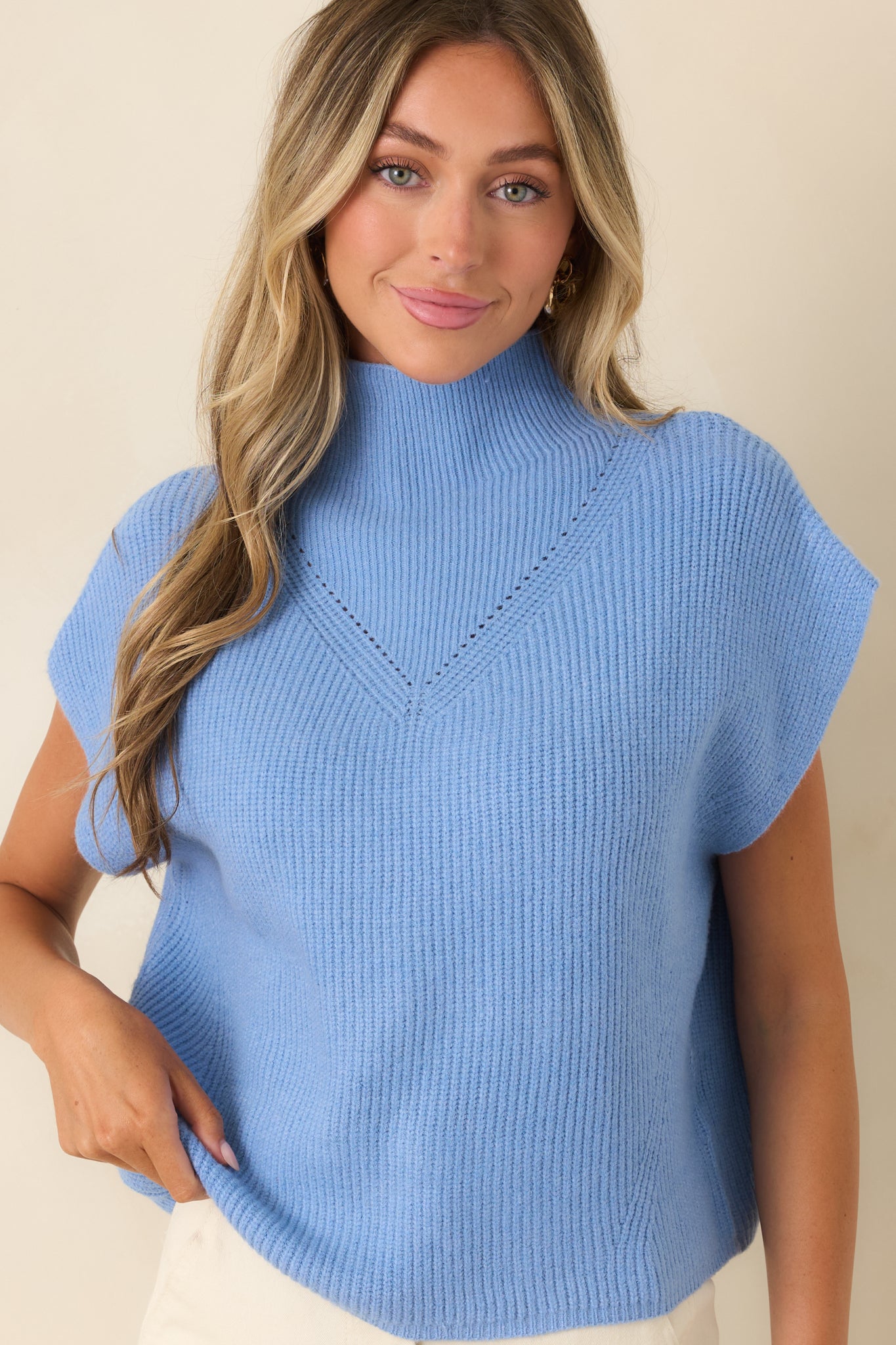 Blue sweater detail showcasing the ribbed knit construction, refined neckline, and smooth polished finish.