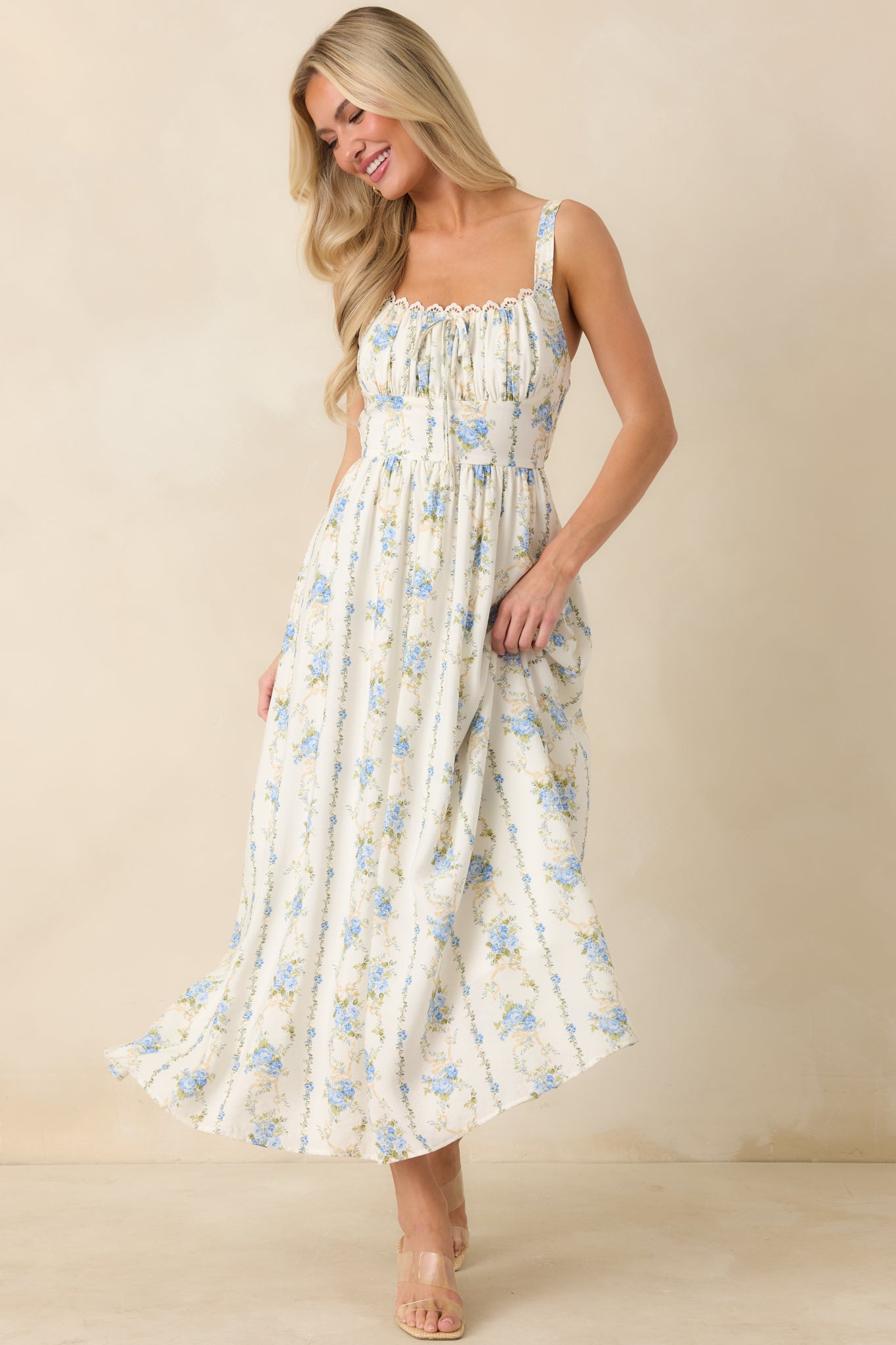 Delicate floral midi dress in blue tones with lace-trim neckline, ruched detailing, and an easy draped silhouette.