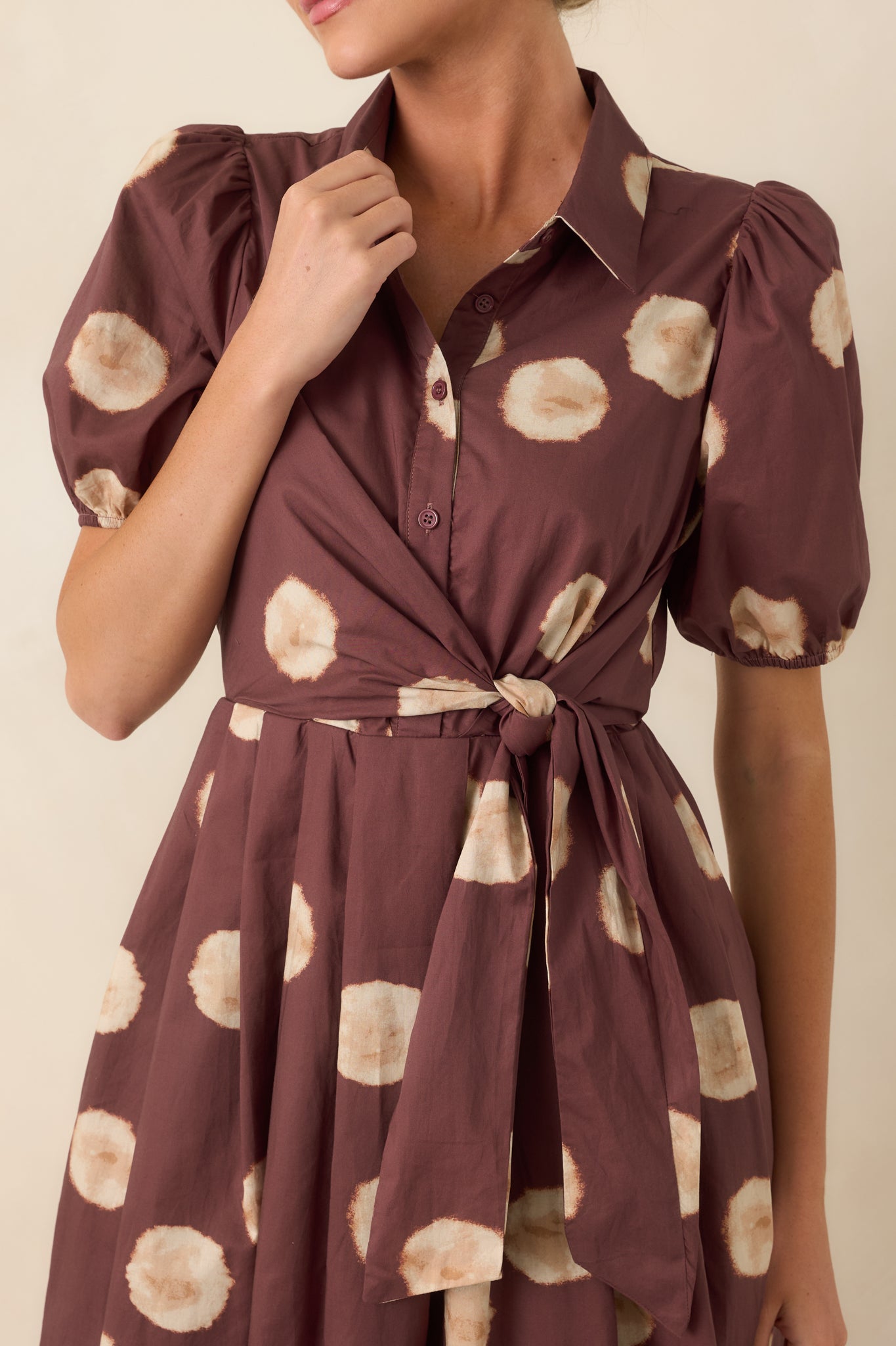 Close-up of the dress showcasing the softly blurred dot print, collared neckline, and functional button-front details.