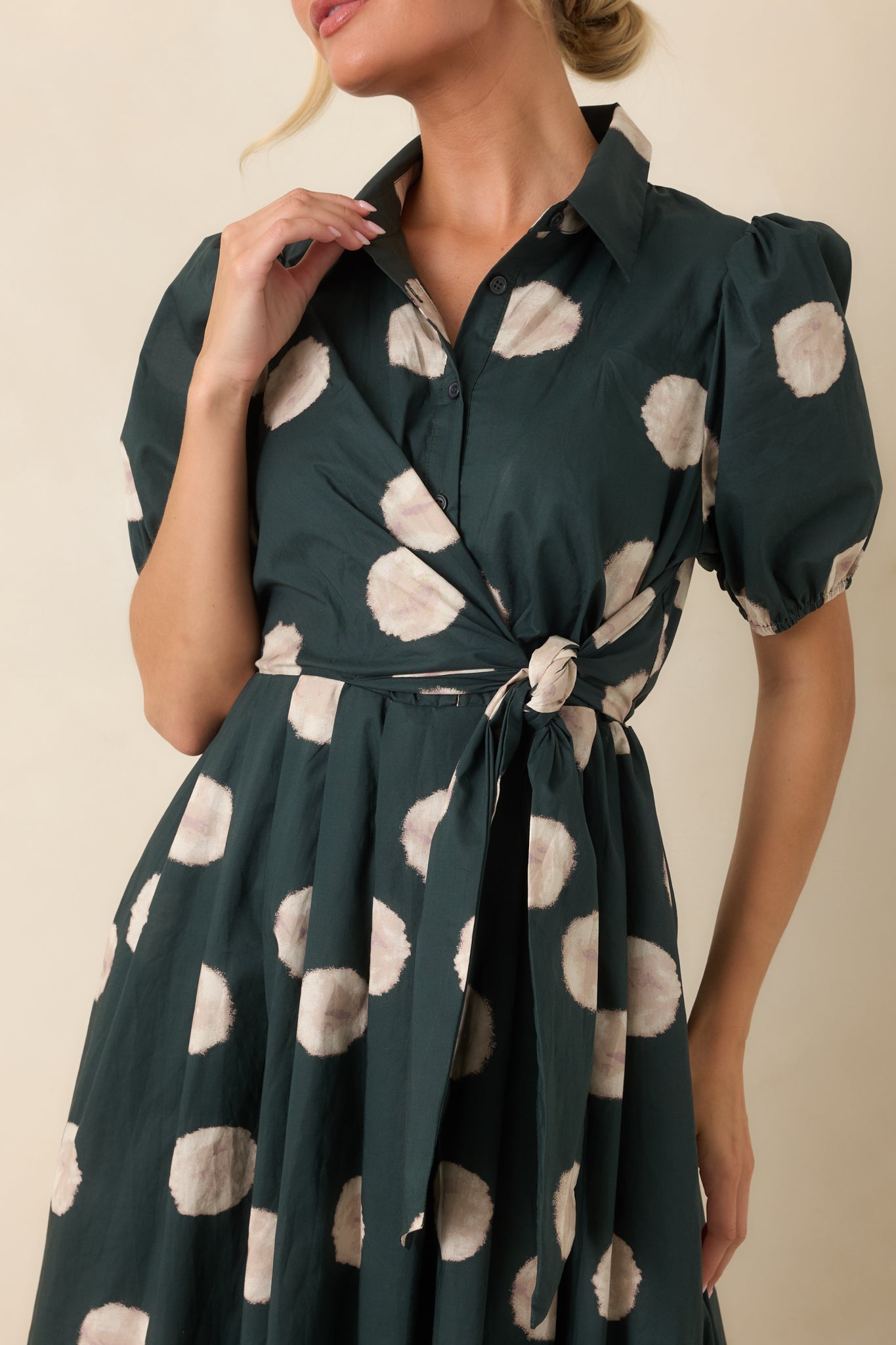 Close-up of the dress highlighting the softly blurred dot print, functional buttons, and collared neckline.
