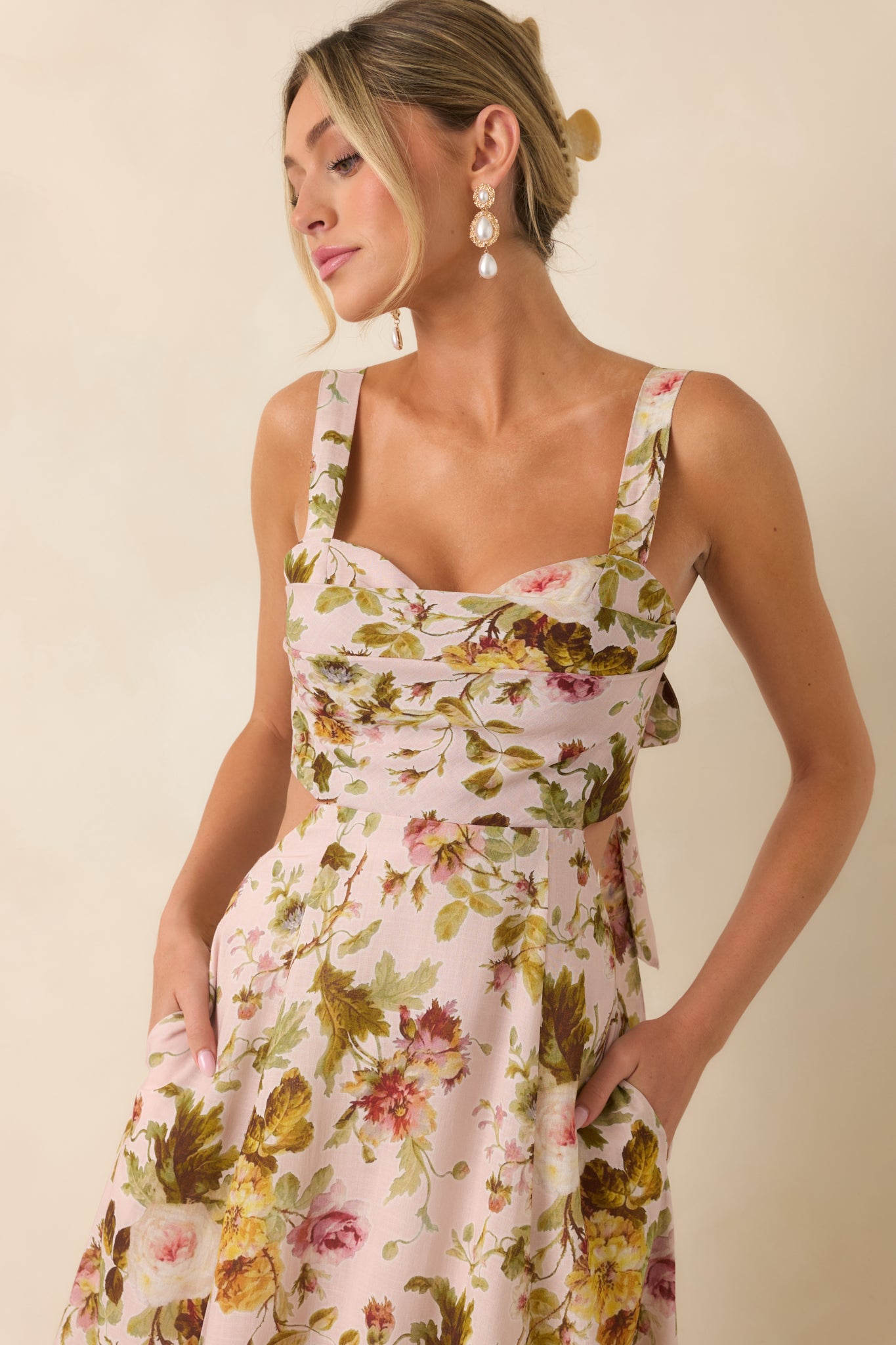 Feminine midi dress showcasing blush pink, golden yellow, and green floral prints with a structured bodice.