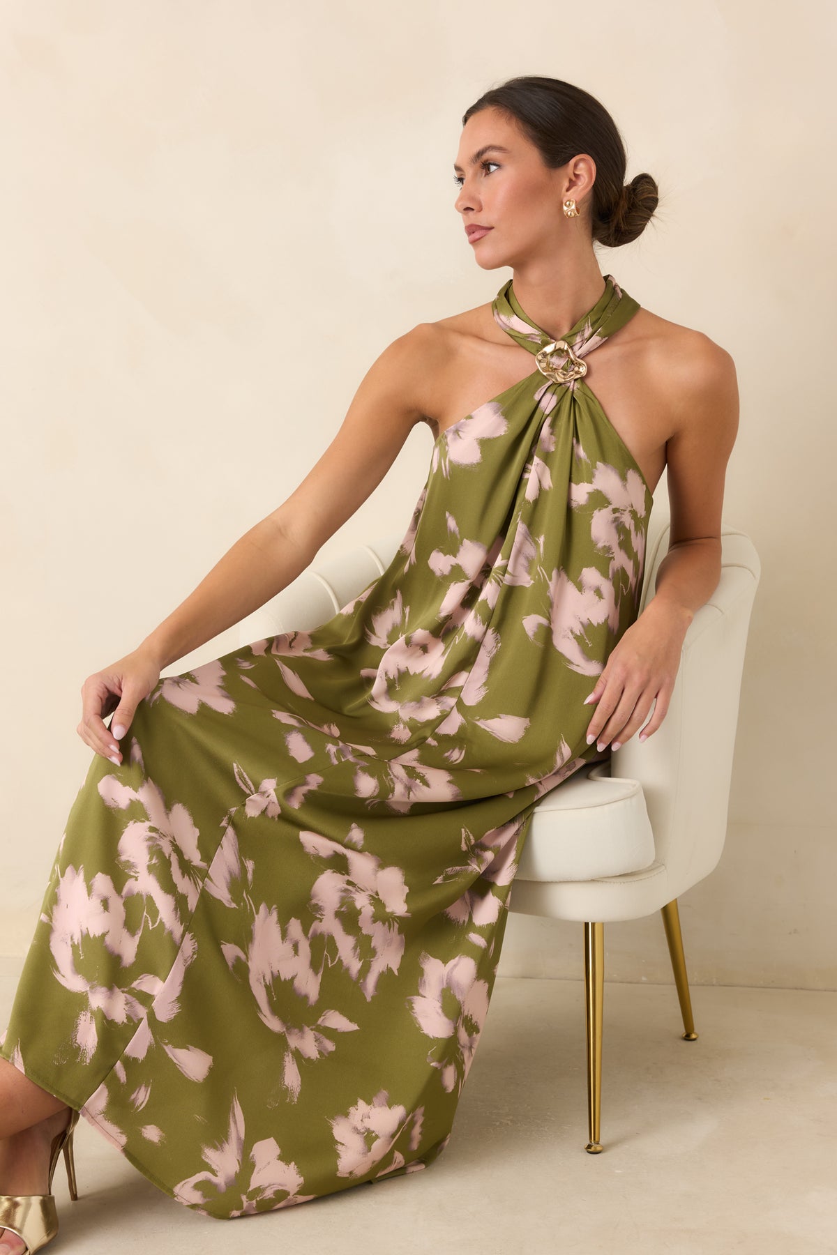 Painterly blush floral dress showcasing the sculptural gold-tone halter detail and softly draped fabric.