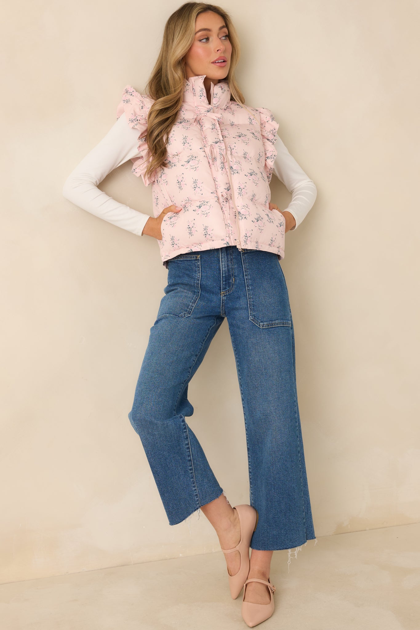 Blush pink puffer vest with quilted floral pattern, stand collar, frilled arm openings, and front self-tie closures for a soft, structured look.